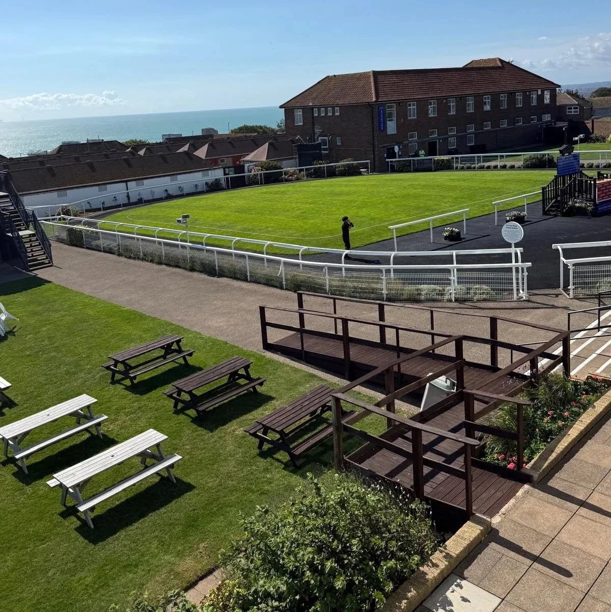 Picnic benches and grounds overlooking the sea at Brighton Racecourse during Streamline Taxis' Martlets Hospice evening