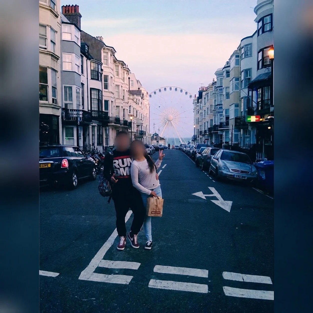 Brighton Wheel framed at the end of a Brighton street between Victorian terraced buildings at dusk
