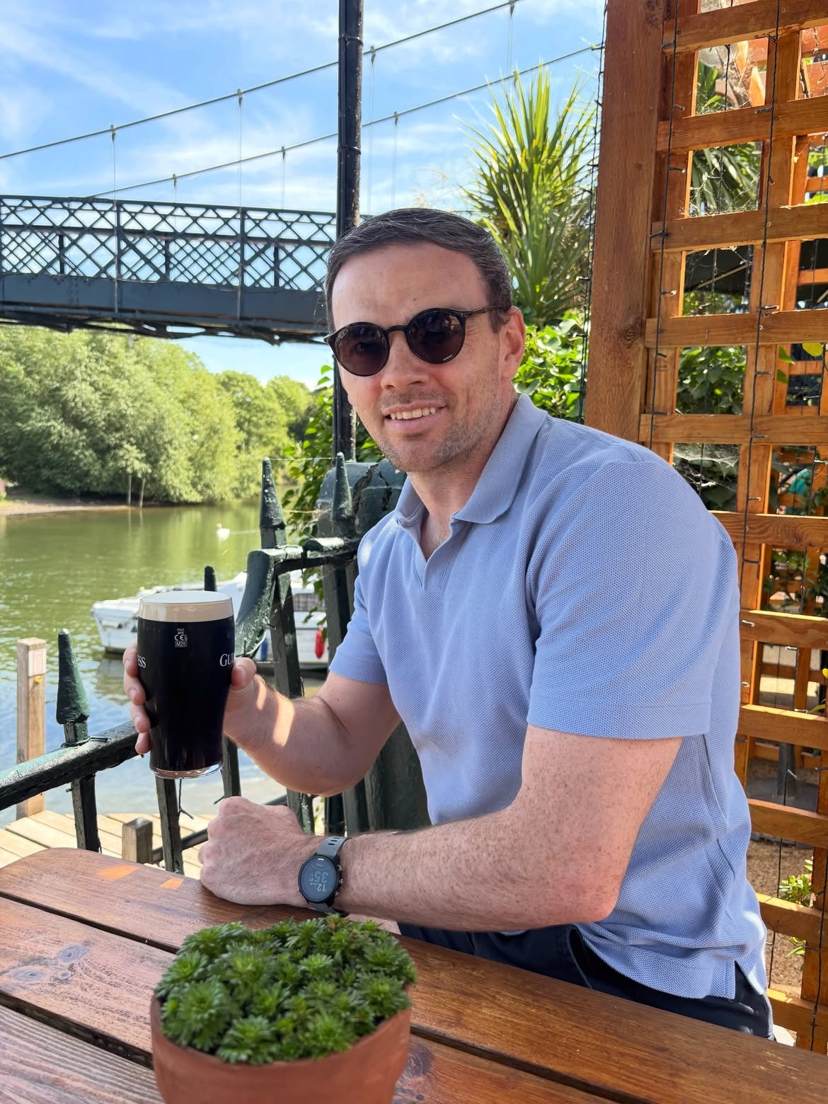 Declan O'Sullivan of TA Fitness sitting outside a riverside pub holding a pint of Guinness