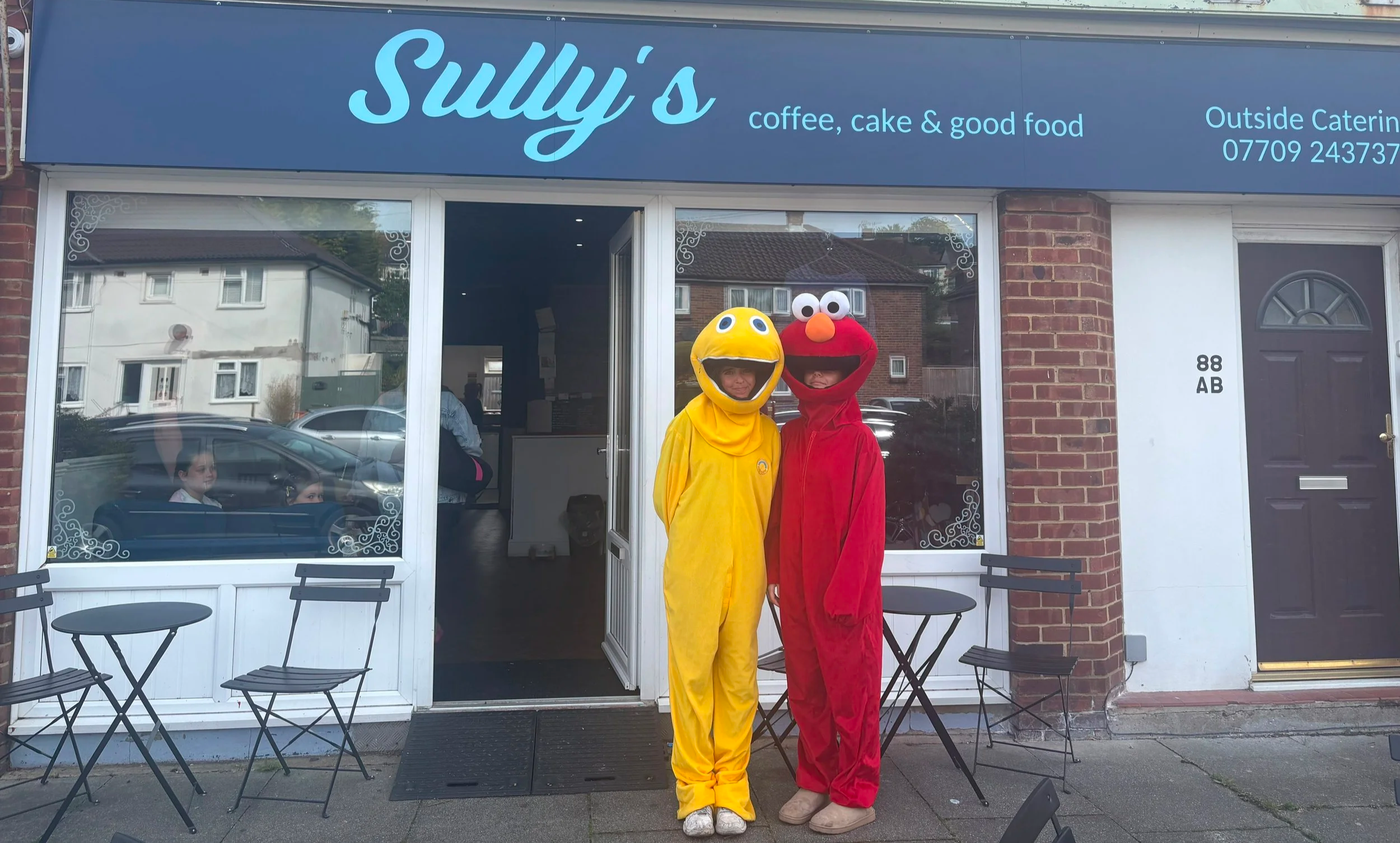 Staff in Zippy and Elmo mascot costumes outside Sully's coffee shop in Mile Oak Portslade