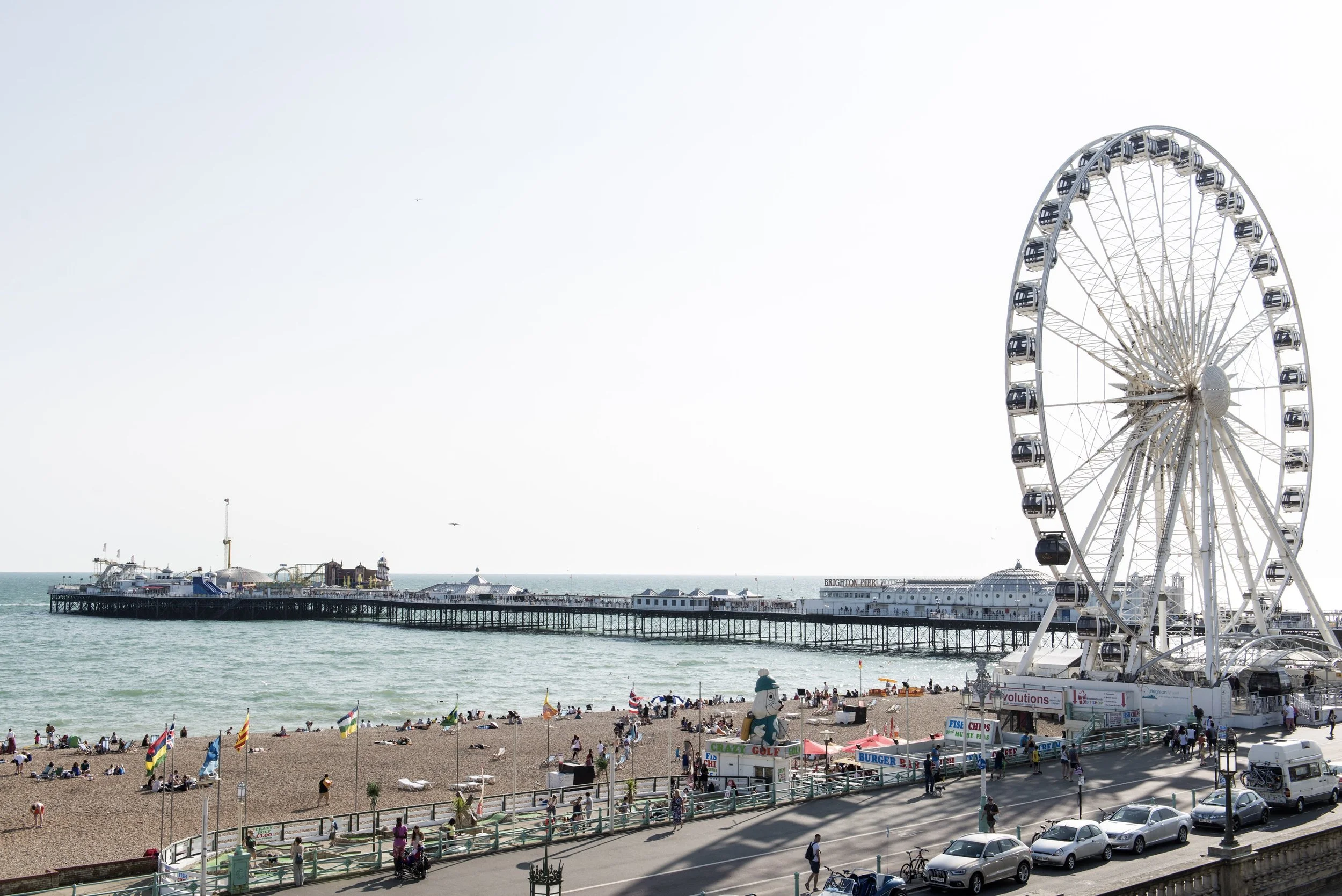 Brighton Wheel on Madeira Drive on a sunny day with Brighton Palace Pier and the beach in the background