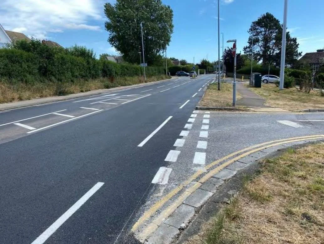 Shirley Road in Hove after micro-asphalt resurfacing, showing a smooth new road surface with fresh white lane markings and tactile paving at a side junction