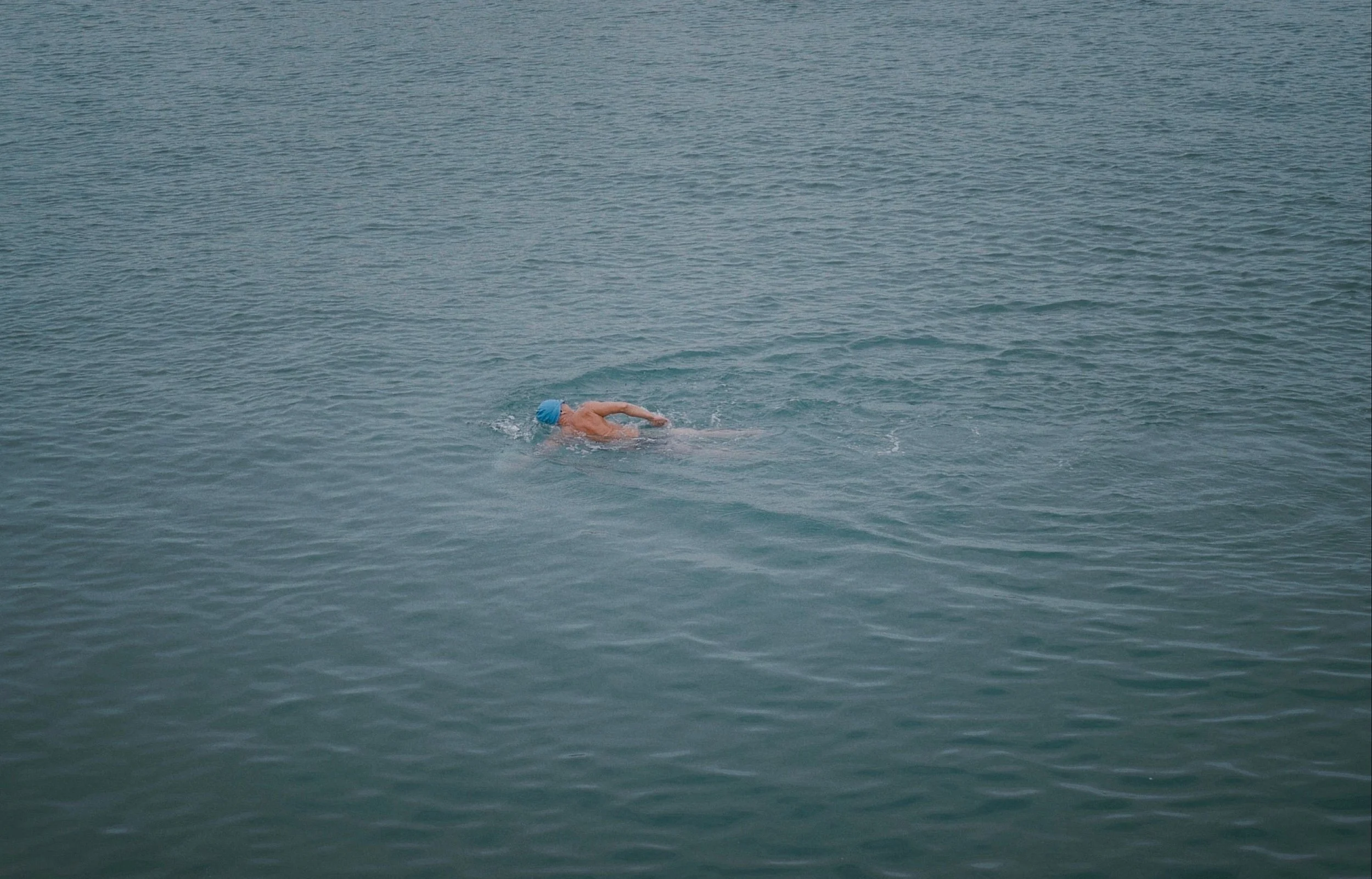 A lone swimmer doing front crawl in open water