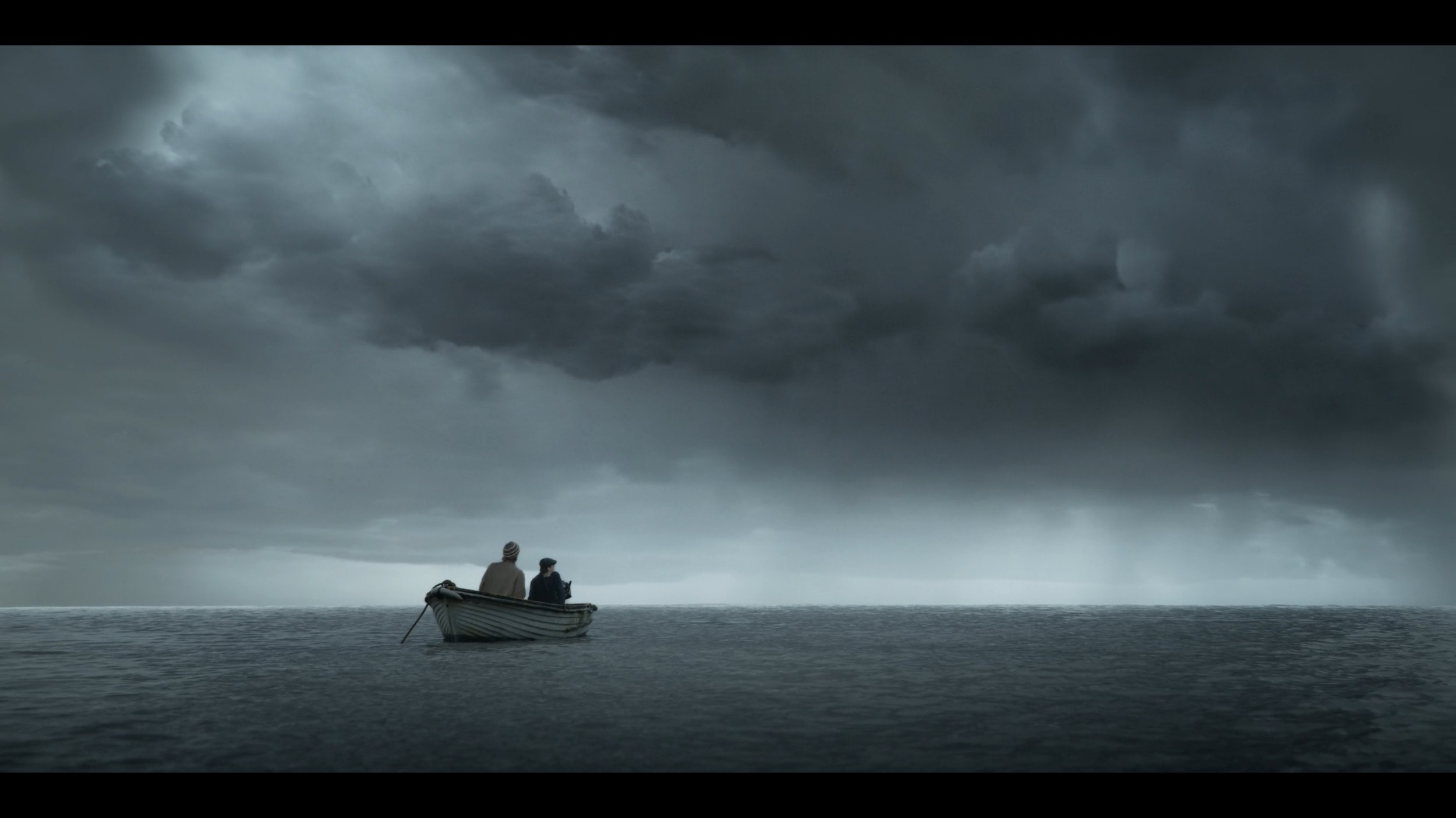 Two people in a small boat on a dark, stormy ocean under heavy, threatening clouds.
