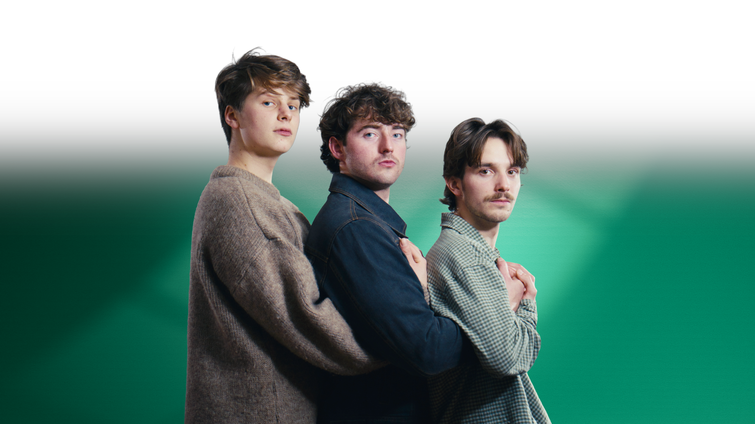 Three young men stand comedically close together, looking at the camera, with a gradient green background. These men are the three founders of Mad Heron - Joe Shale, Jasper Pagan and Lewis Kerr.
