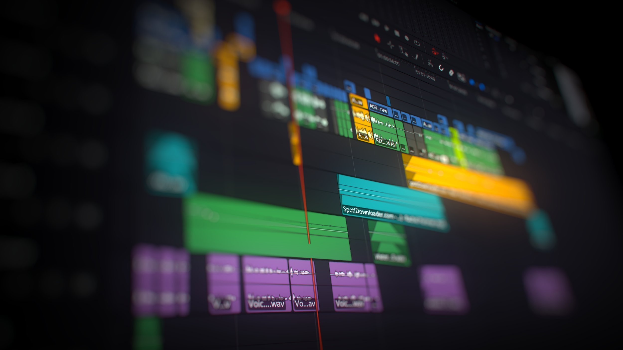 A computer screen displaying a digital editing workstation with various colourful audio and video editing tracks. Editing. DaVinci Resolve. Premiere Pro. Final Cut. AVID. Industry-standard.
