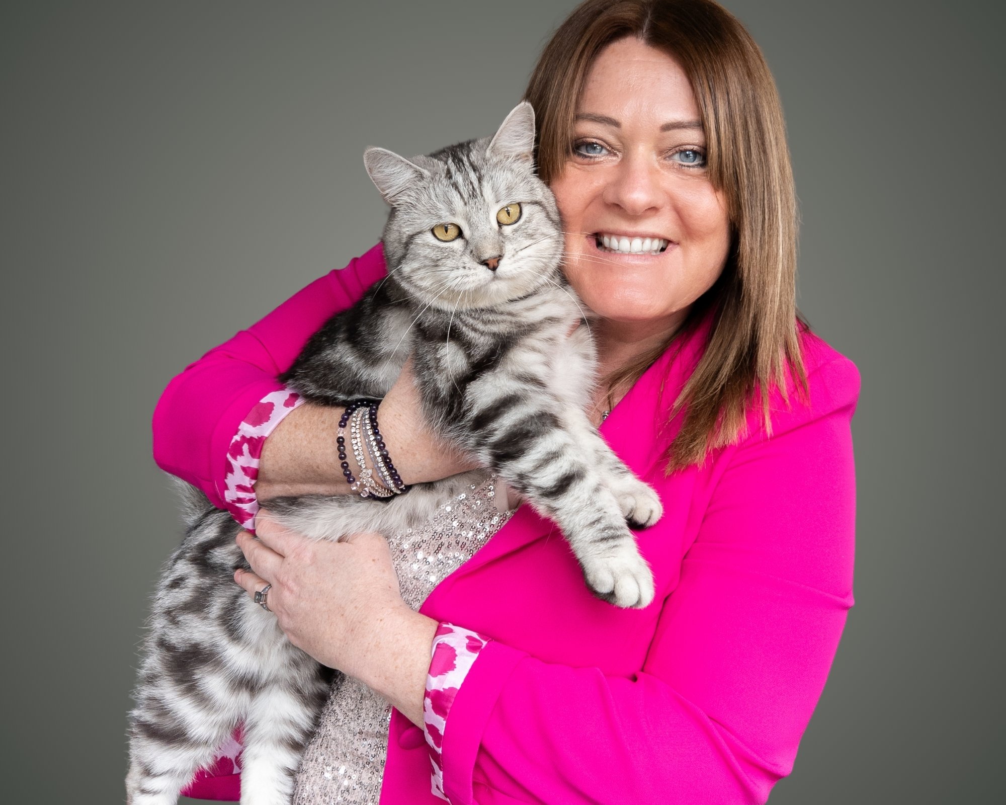 Helen with silver the cat against a grey background.