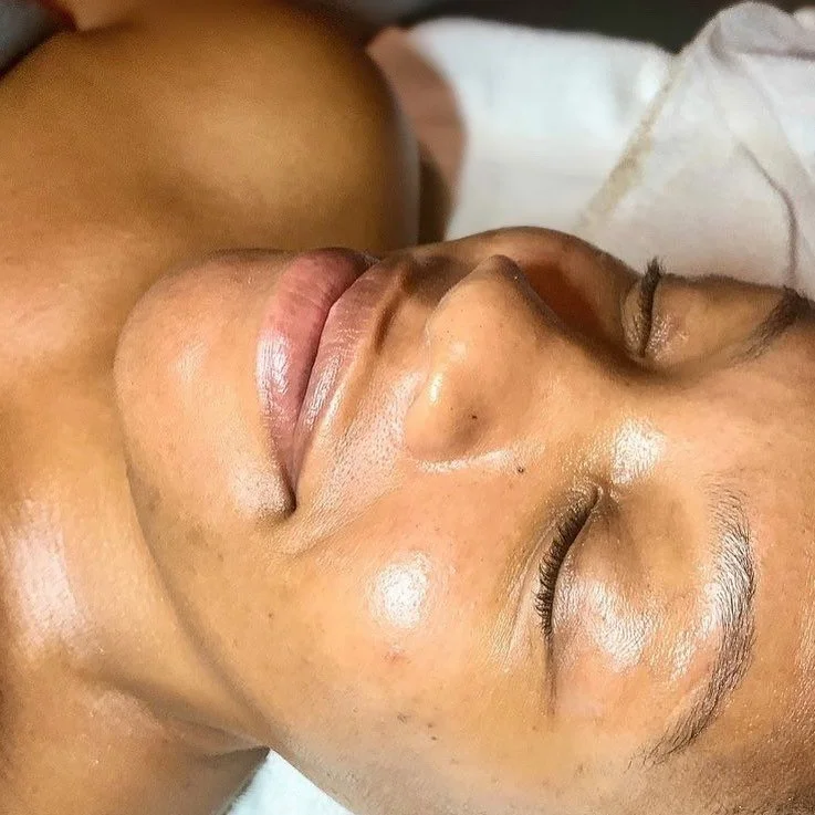 Close-up of a person's face with eyes closed, lying down, showing smooth skin and lips.