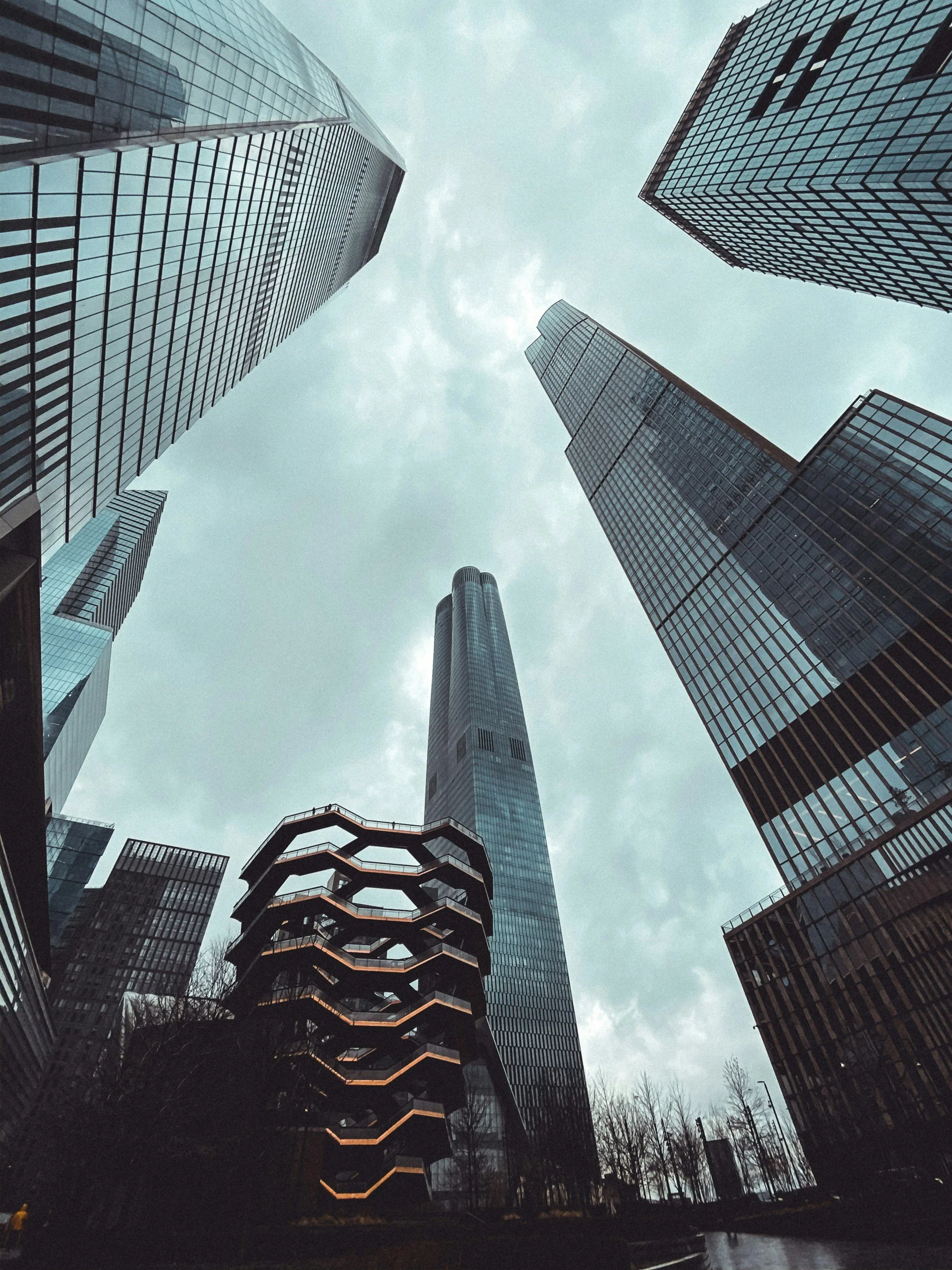 View of skyscrapers from below looking up at cloudy sky.
