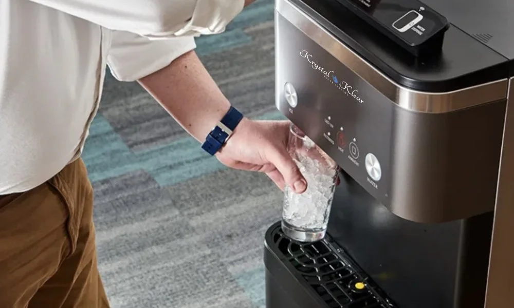 Person filling a glass with water from an ice and water dispenser machine.
