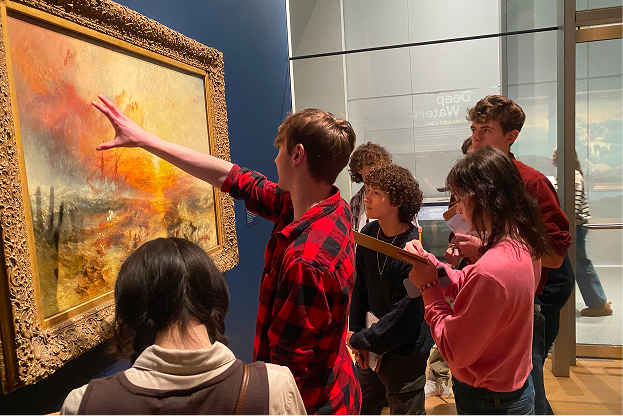 Group of children and a young man observing and discussing a large, framed painting in an art gallery.