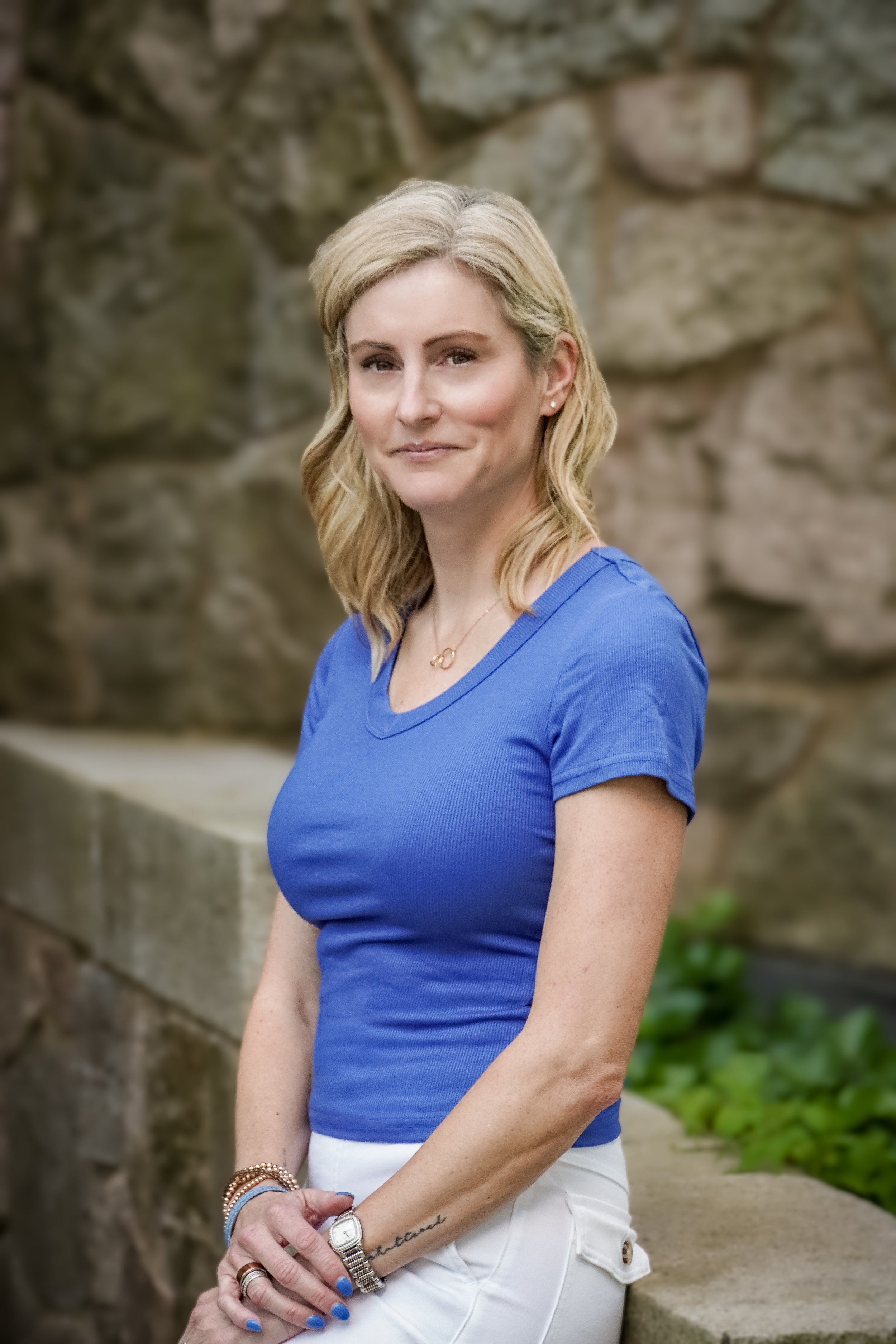Kim in blue leaning against wall