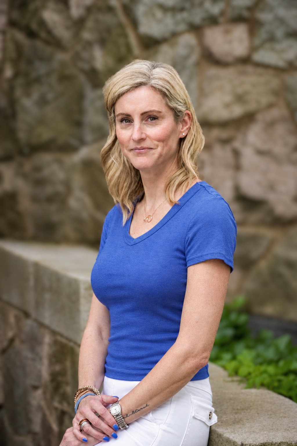 Woman leaning against a wall dressed in blue