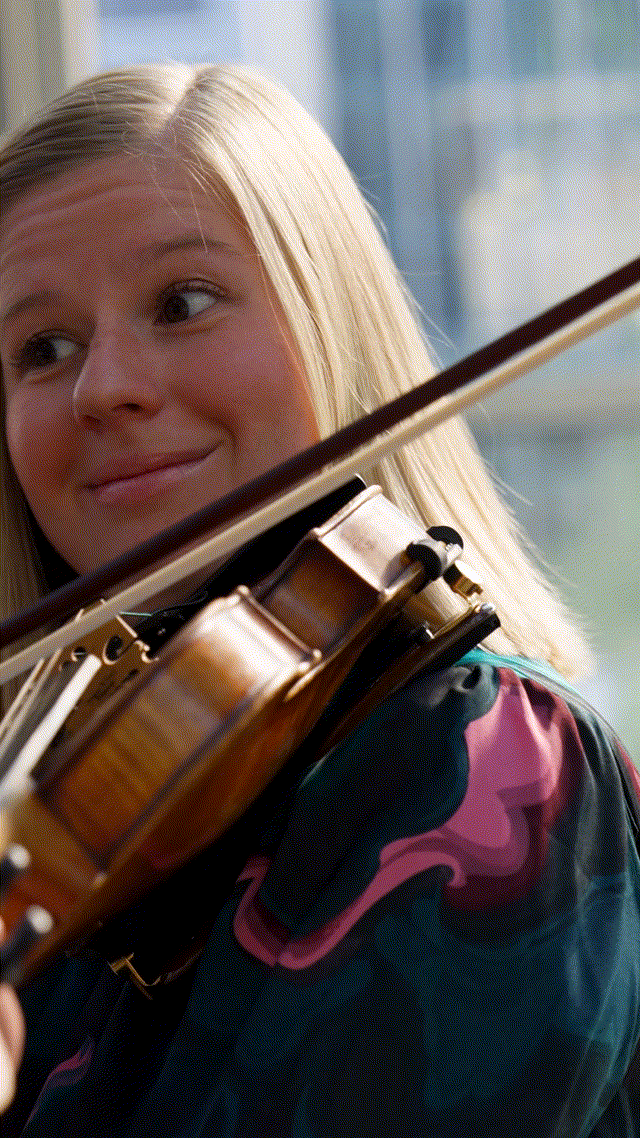 Several stills of Amber Hooke playing the violin cycling in short succession to suggest movement.