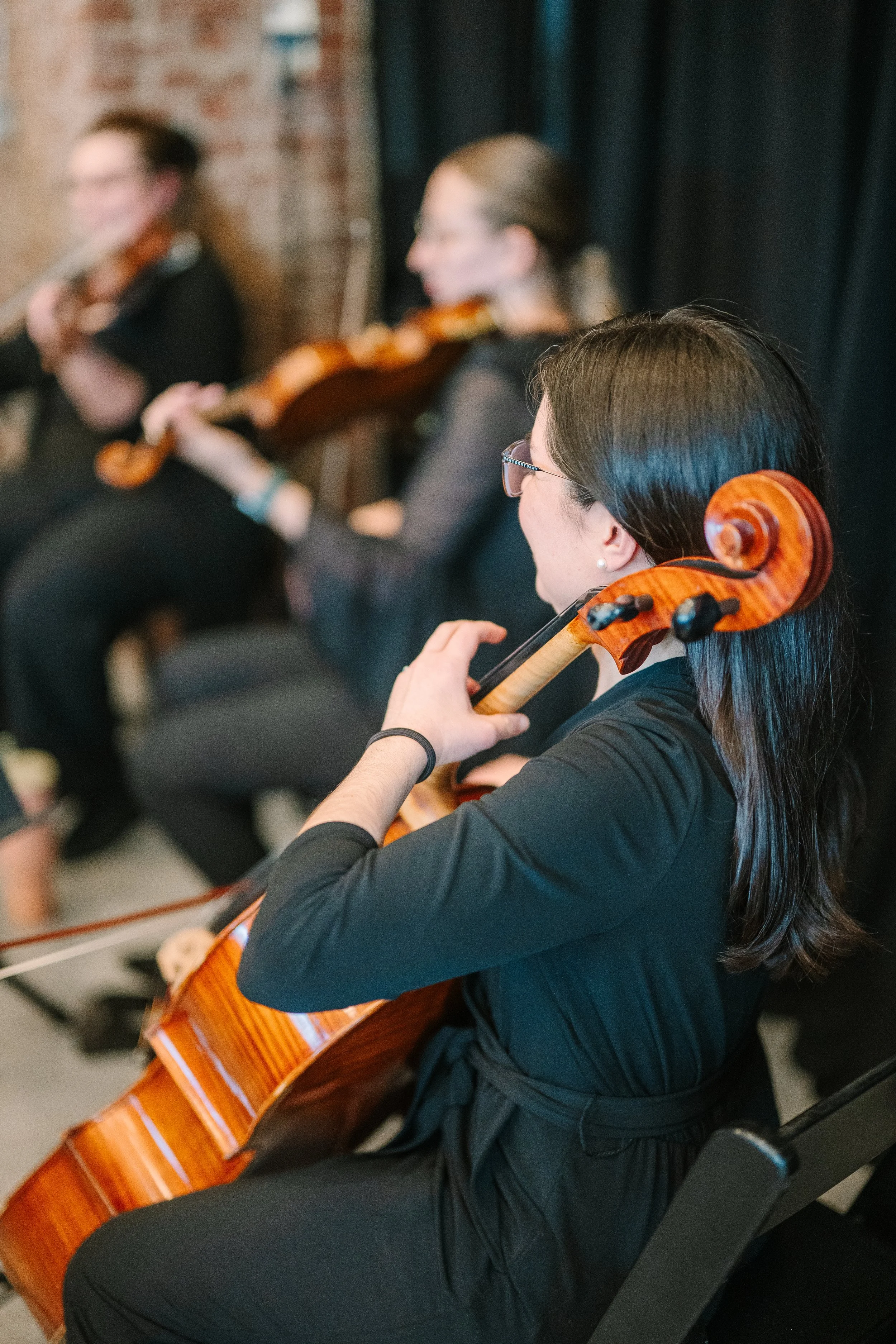 Radiant Strings playing for a musical performance, seated in a row.