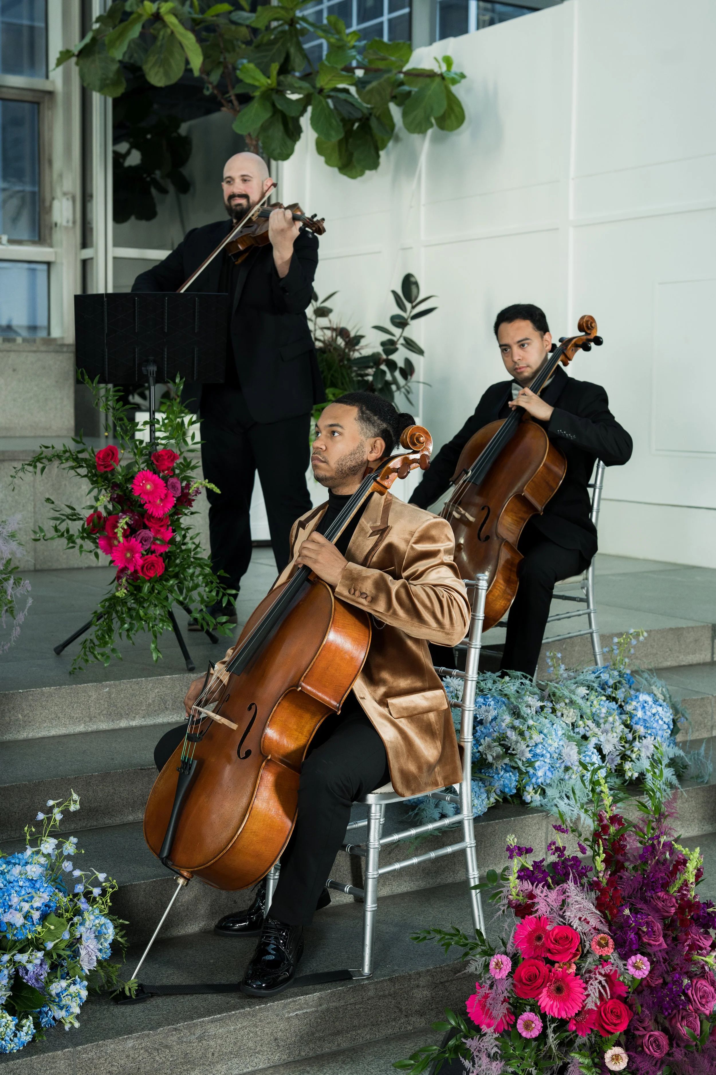 Ahmer'e Blackman performing with Radiant Strings on a decorated stage with flowers.
