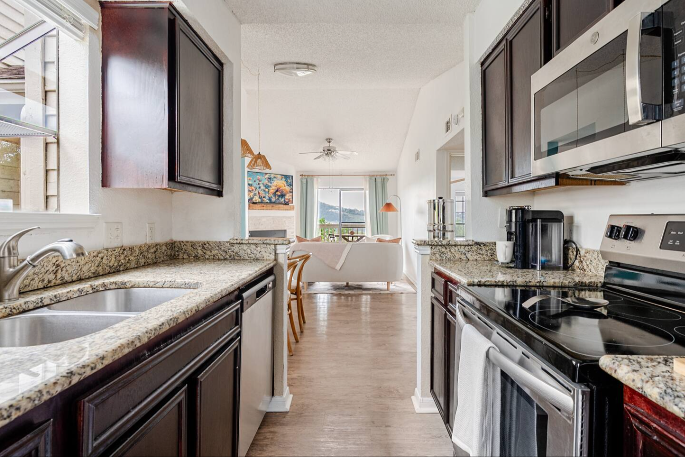 Vacation rental STR living room unique design refresh with color blocking using gold and peach paint on walls, brass details, scalloped rug and wavy cornices by Kvistad Interiors in Austin.