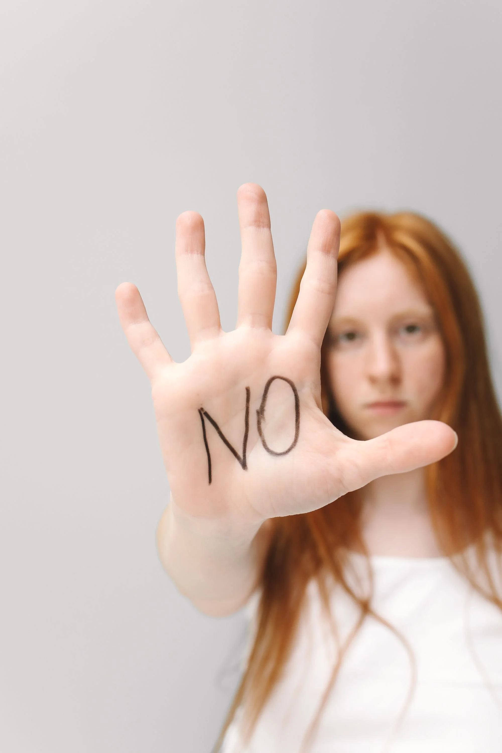 a person holding up their hand with the word no on it