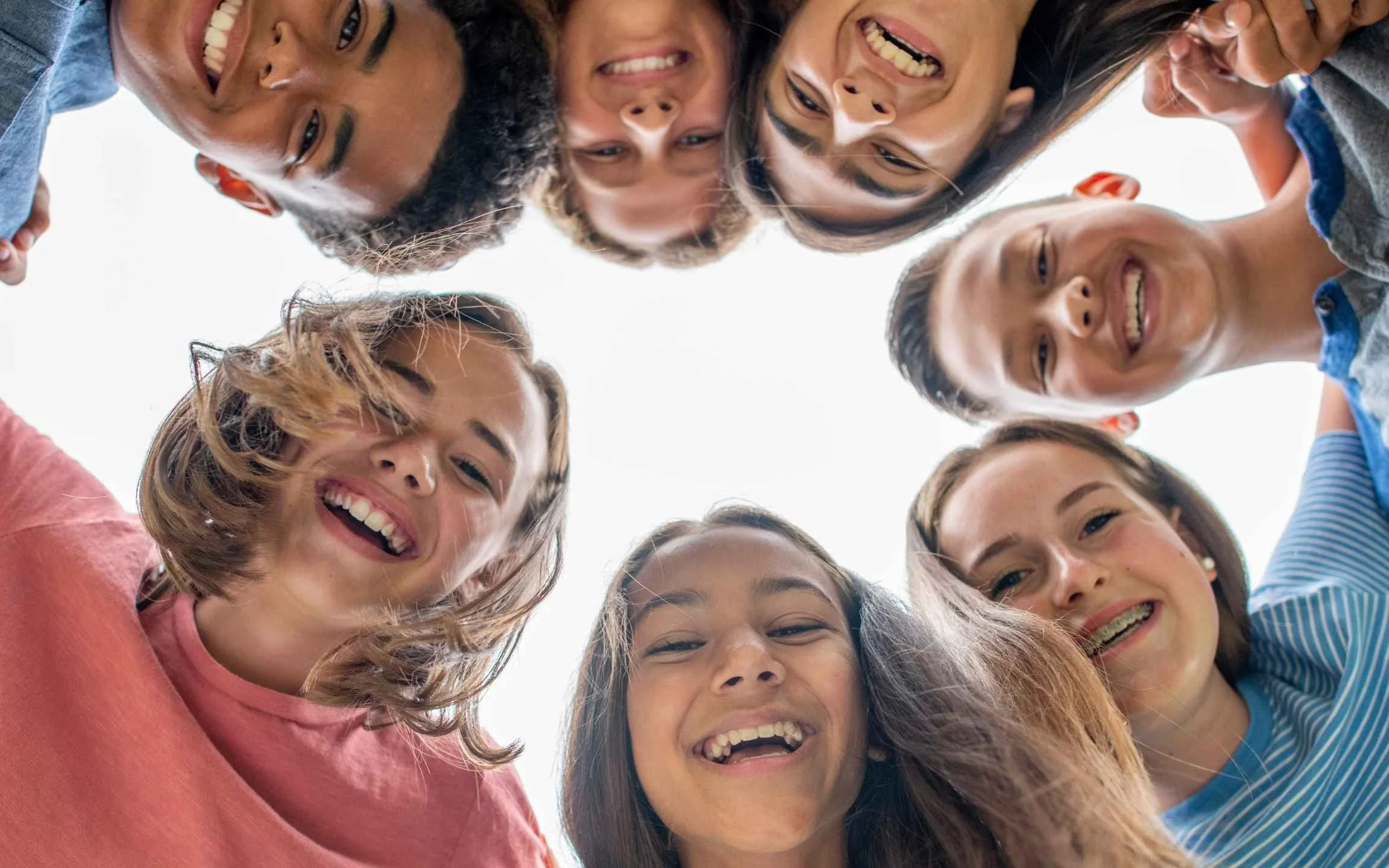 a bunch of kids in a circle looking at the camera