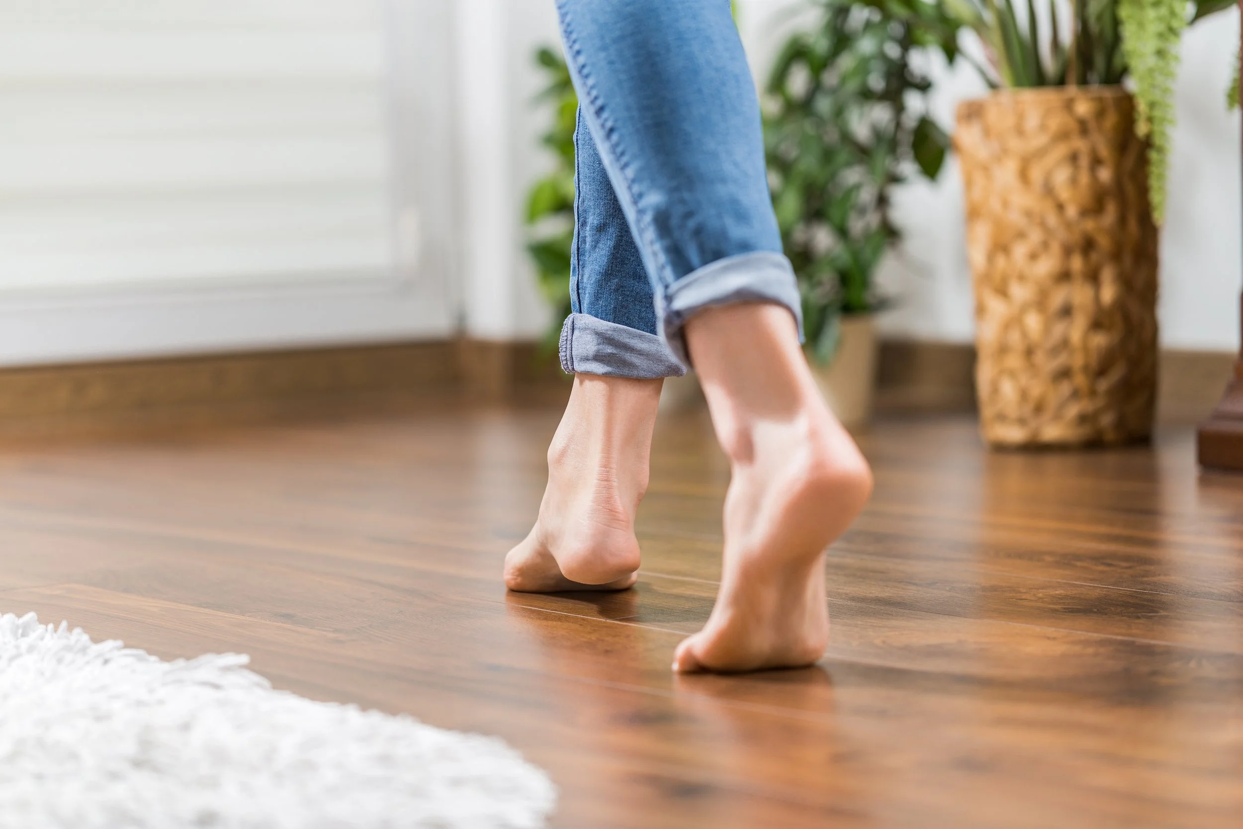 Person barefoot on wooden floor, feeling the warmth after the underfloor heating installation