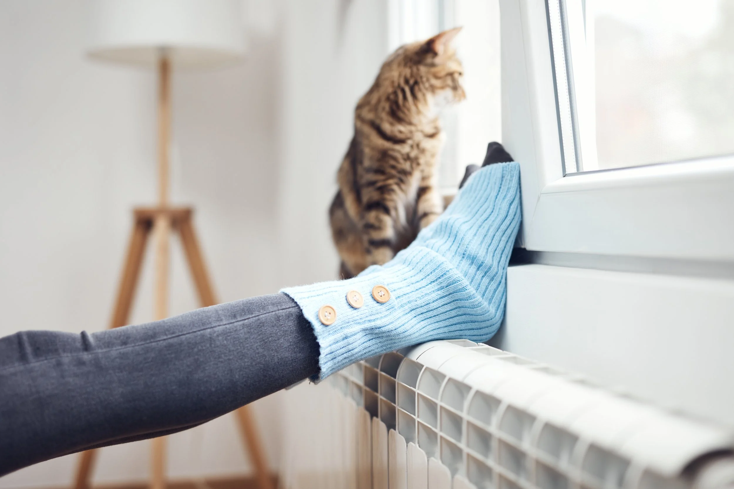 lady putting her feet on the radiator after the boiler service  Roehampton