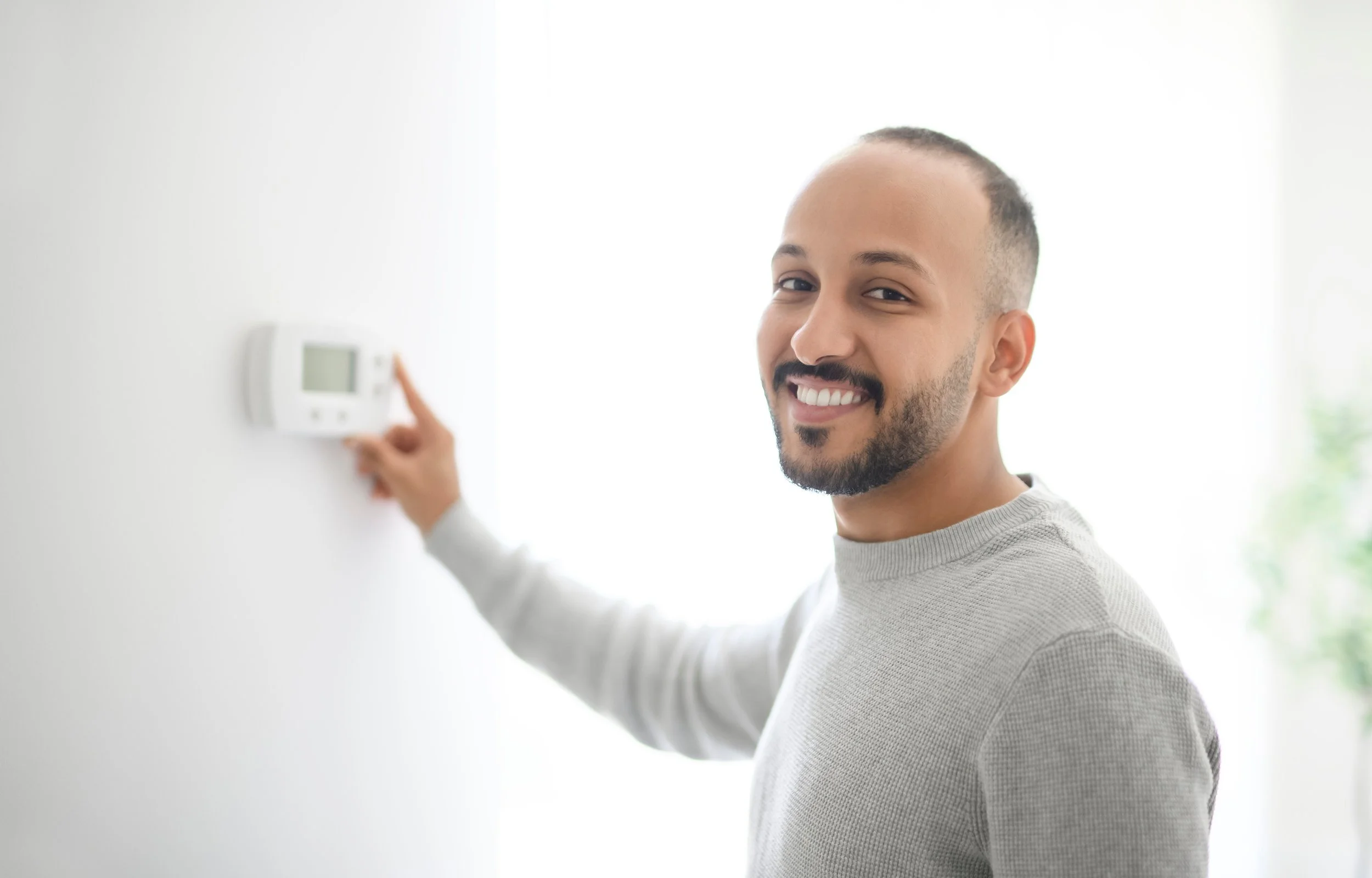 Man adjusting the thermostat after boiler service
