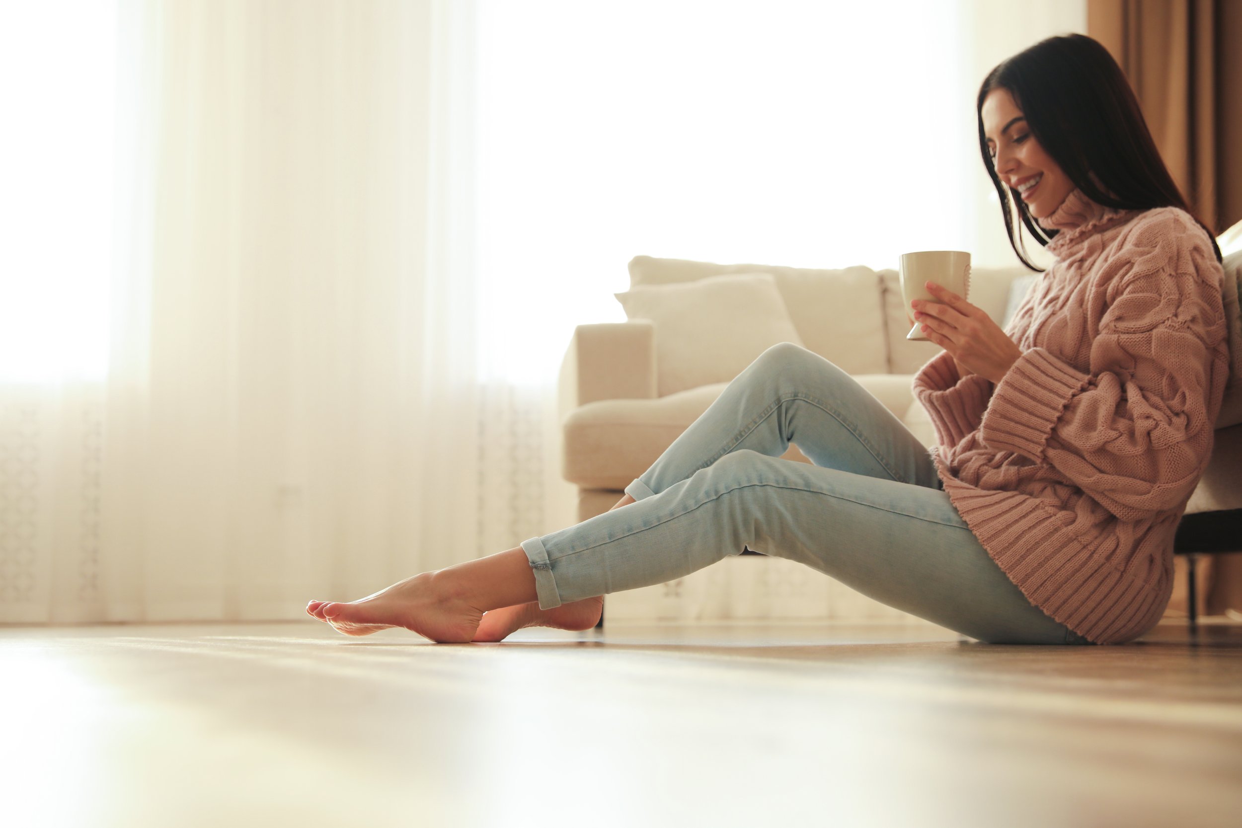 Lady drinking tea on the floor after underfloor heating service