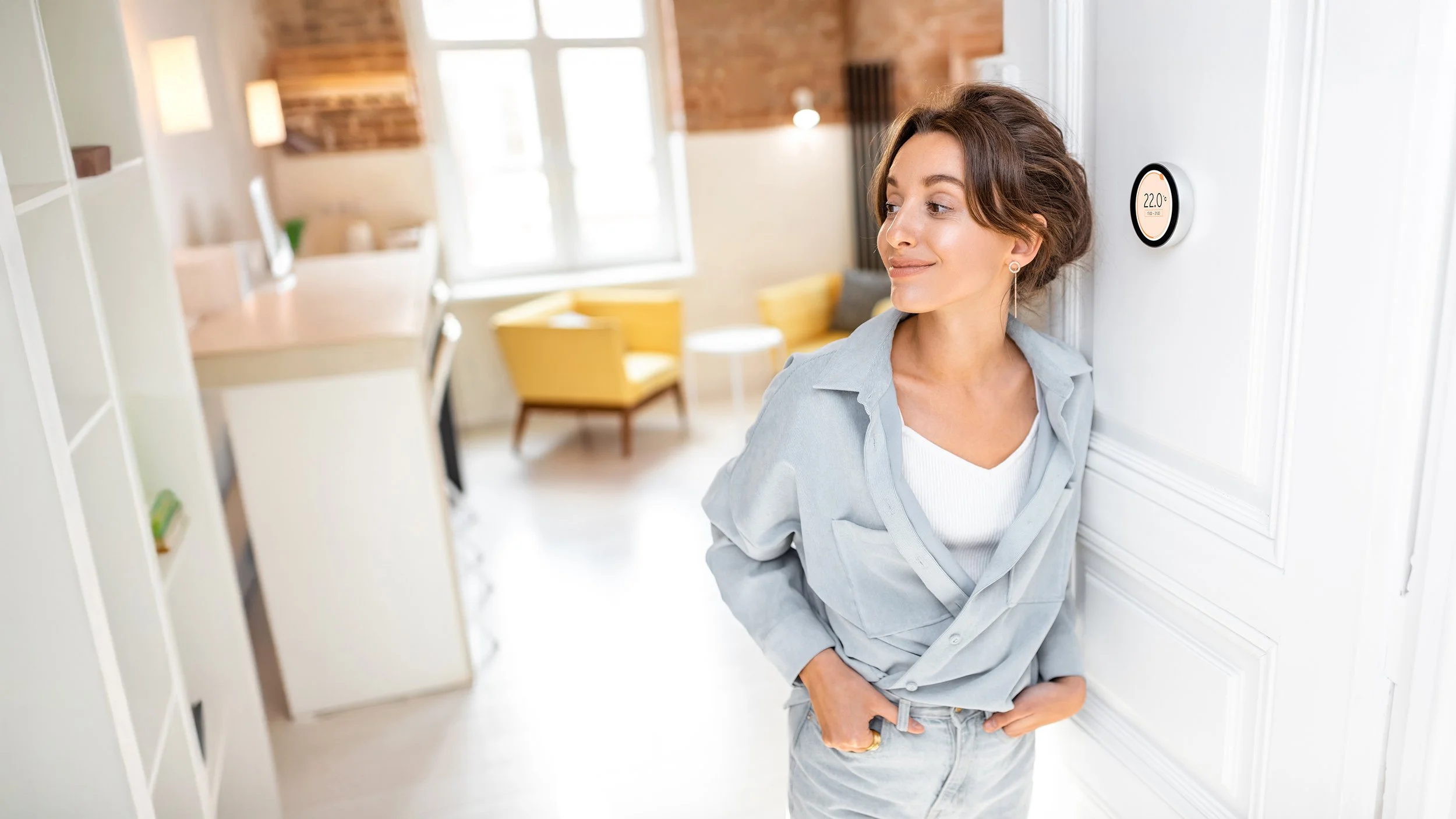 Woman by the thermostat after the boiler repair