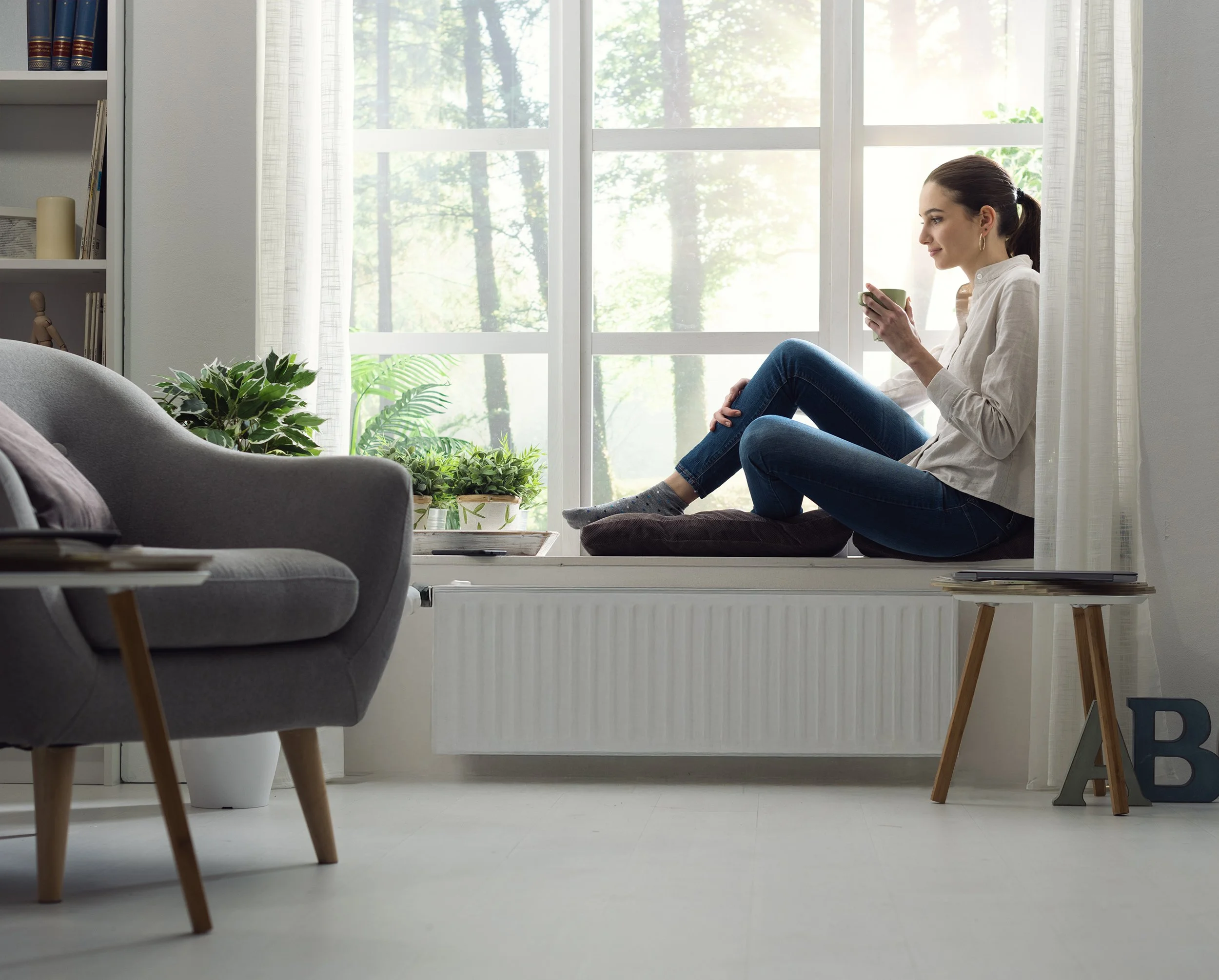 Lady sitting the by the window after the air source heat pump service