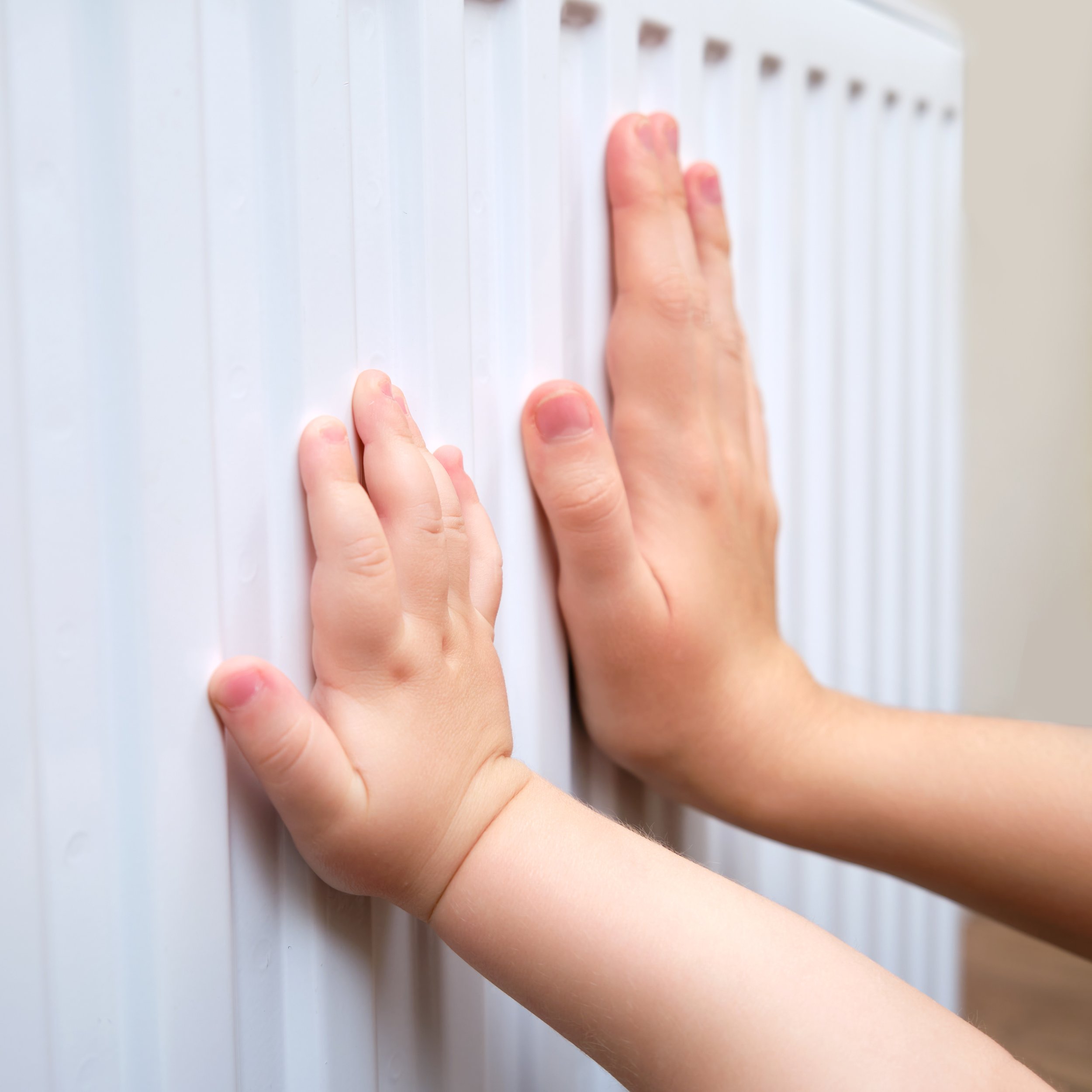 Children feeling the warm radiator after boiler service in Earlsfield