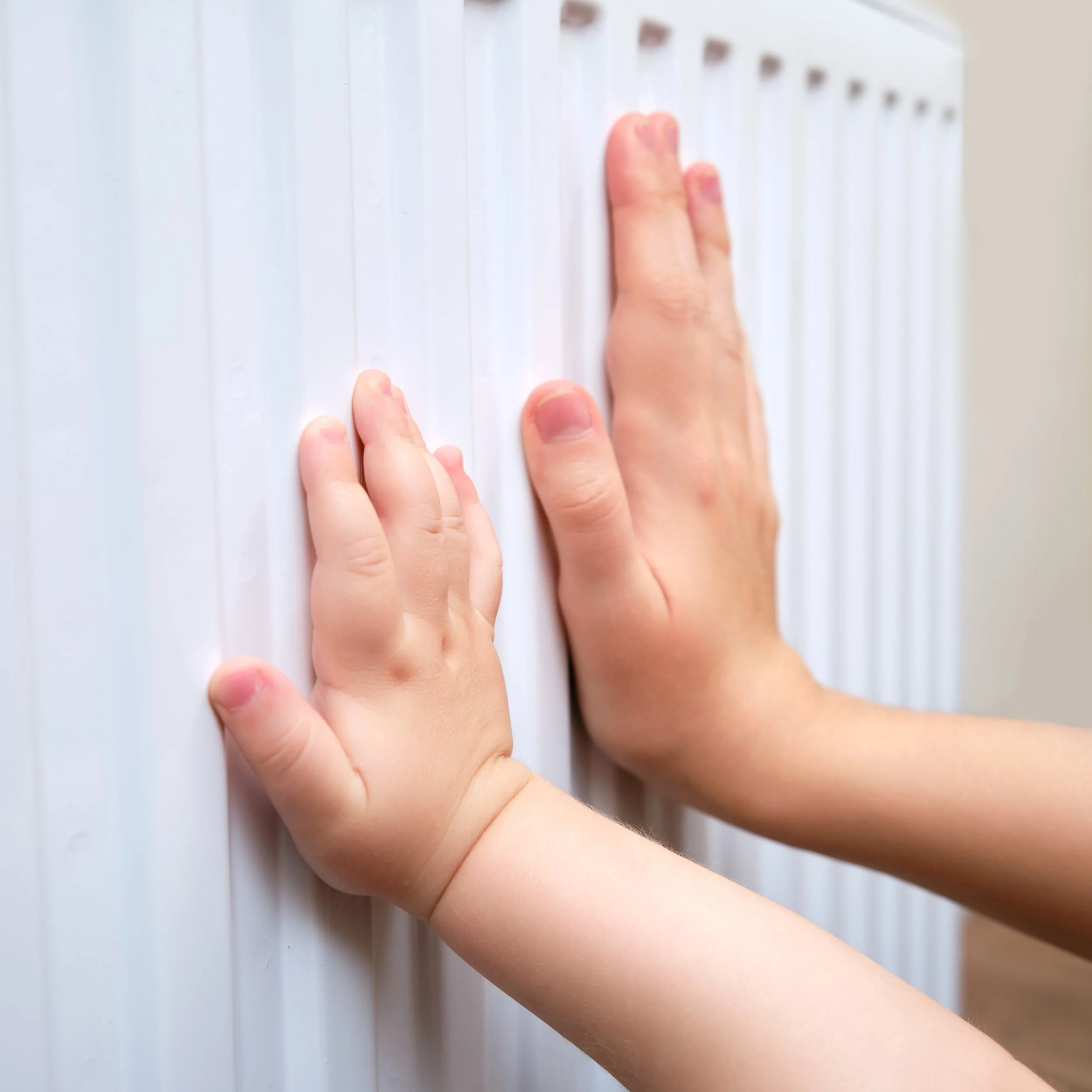 Children feeling the warm radiator after powerflush