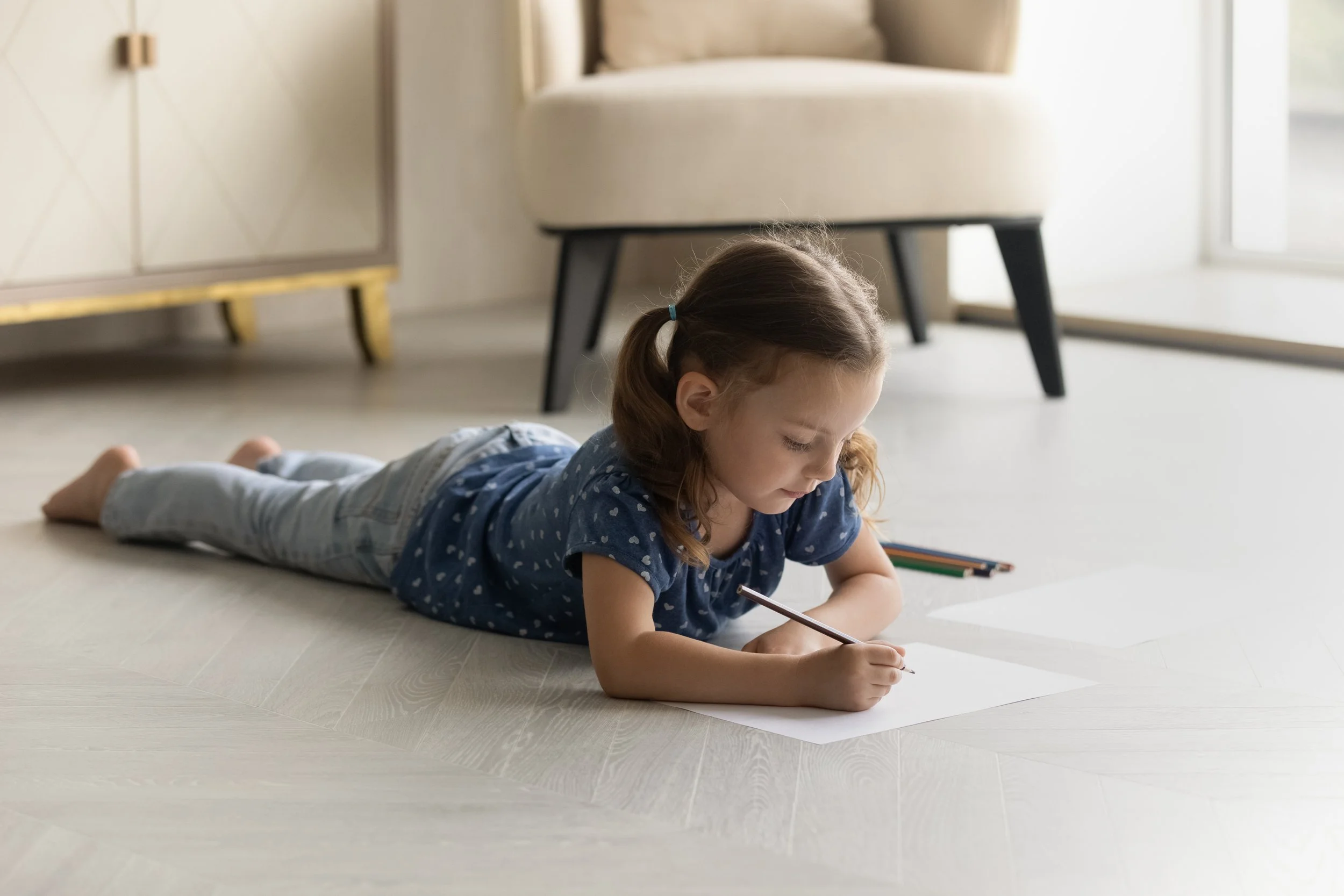 Child writing on warm floor because of underfloor heating