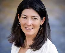 A woman with dark hair and hoop earrings smiling outdoors. Laura Buhl Secretary of the board of directors