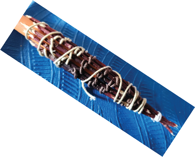 A bundle of sticks tied together with rubber bands on a blue textured surface.