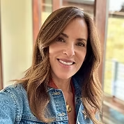A woman with shoulder-length brown hair wearing a denim jacket, smiling outdoors near a house with large windows. Sheryl Haft Flug
Vice-President of the board of directors