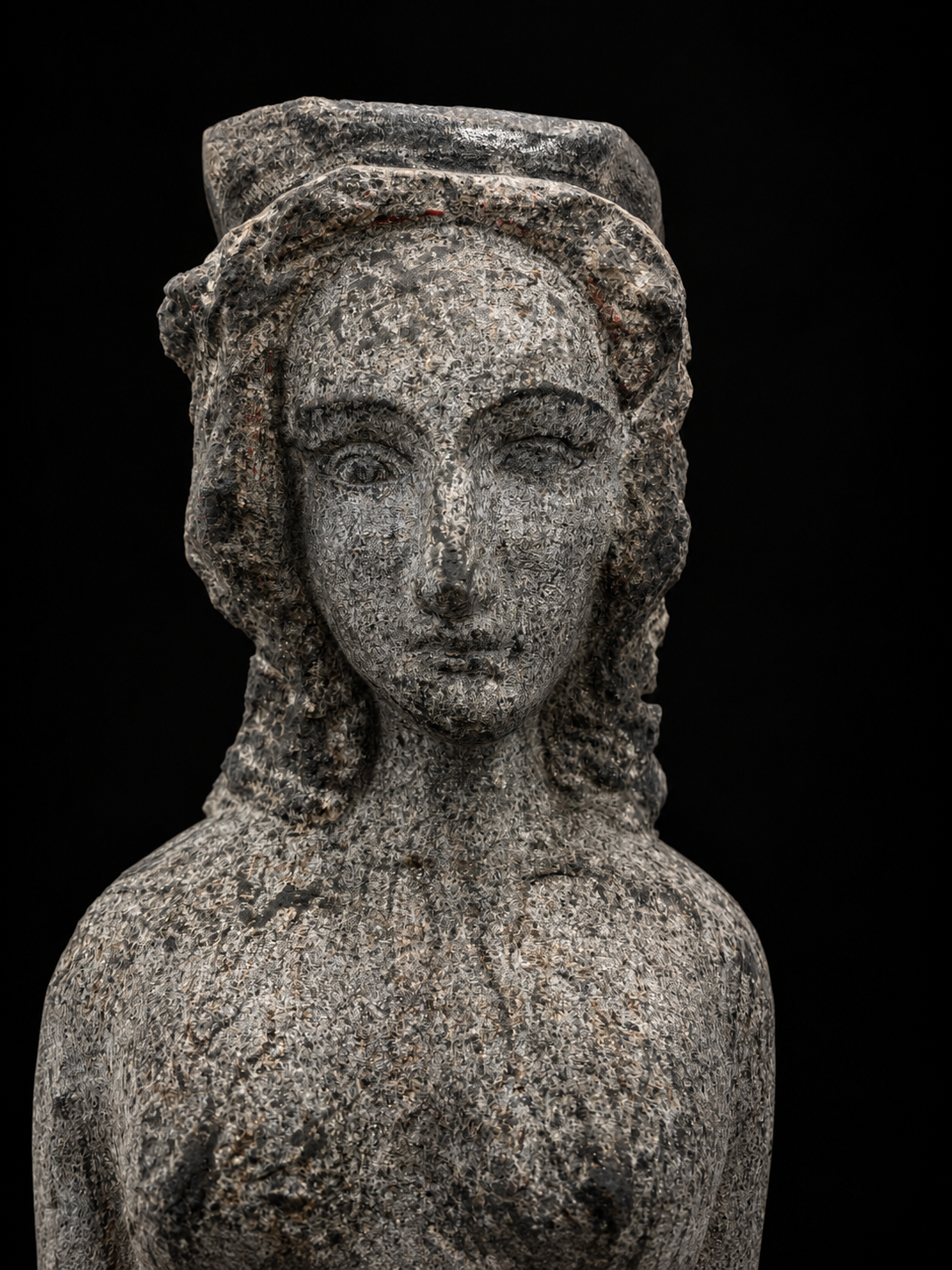 Détail du visage de Reine, sculpture en granit de Florence Jarrige, artiste sculpteur à Cluny en Bourgogne, révélant le travail de taille de pierre et la présence féminine de cette œuvre d’art contemporaine.