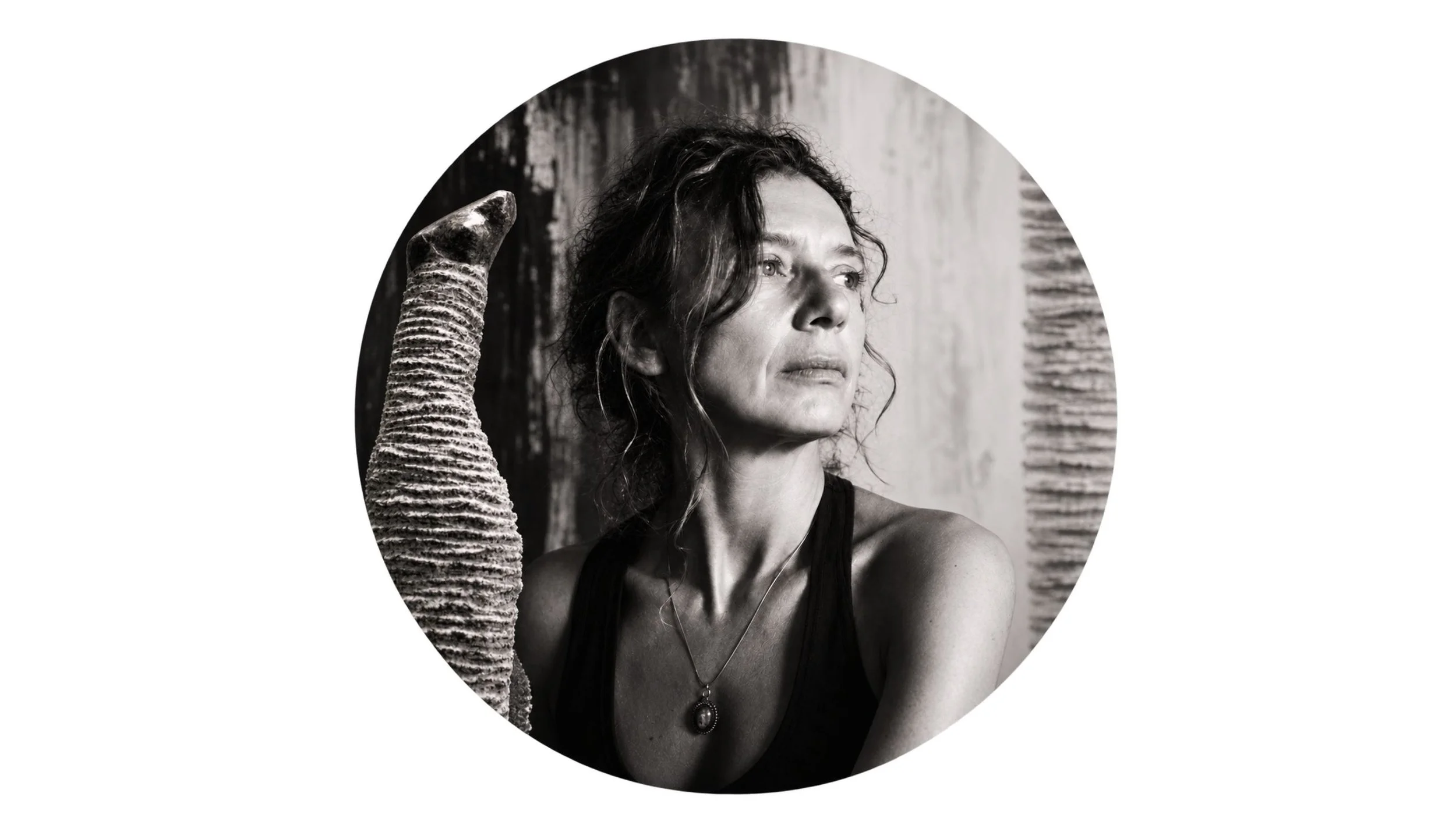 Portrait de Florence Jarrige, artiste sculpteur contemporain à Cluny en Bourgogne, entourée de ses sculptures en pierre