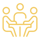 Three people sitting at a table in a discussion.