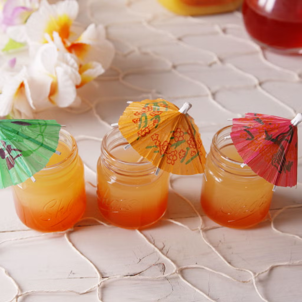 a shot of liquor with a tiny umbrella