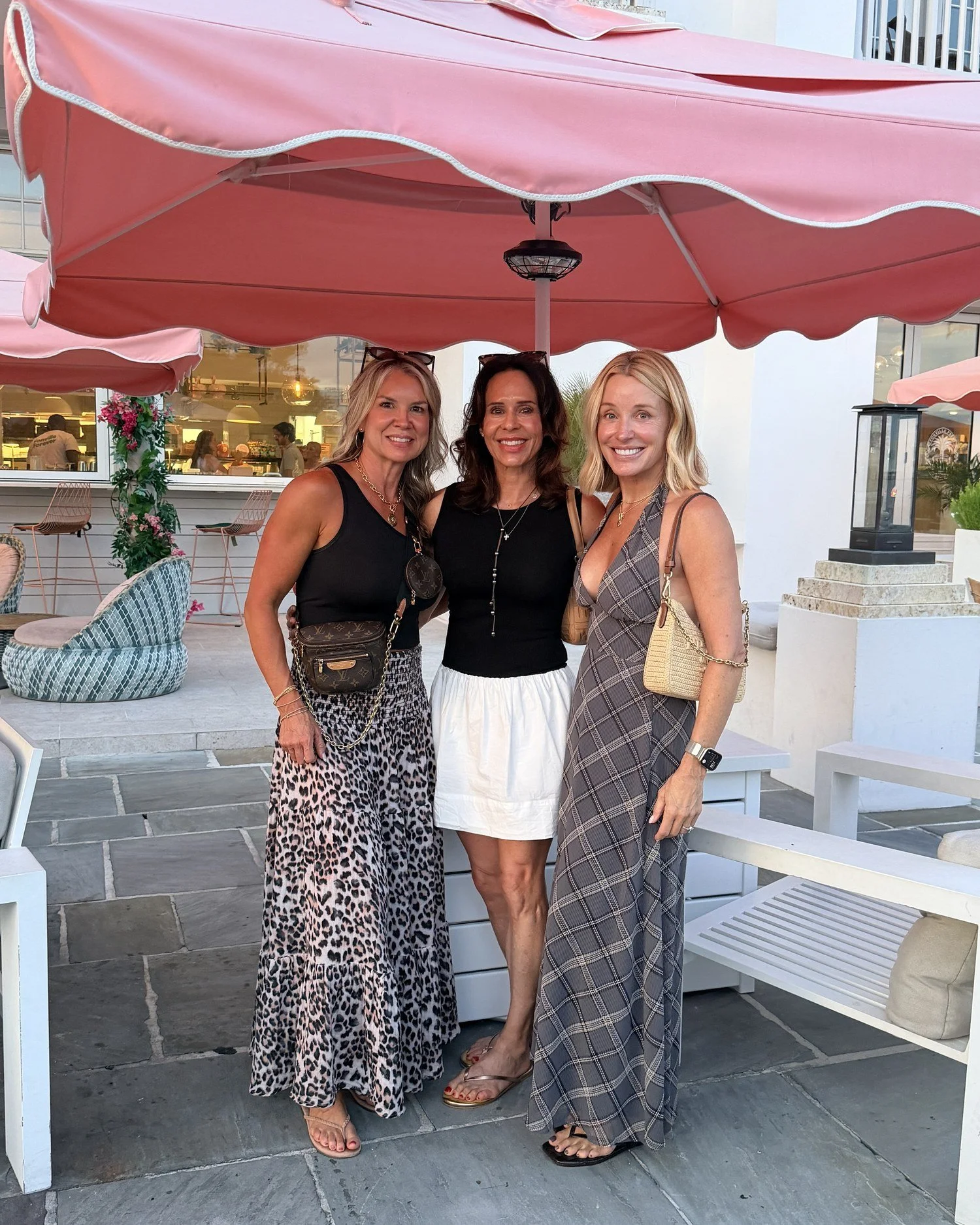 Three women dressed for dinner on a girls trip to the beach