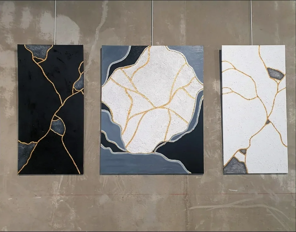 trois peintures représentant le concept kintsugi: des fragments noirs, gris et blancs recomposés avec des lignes d'or.