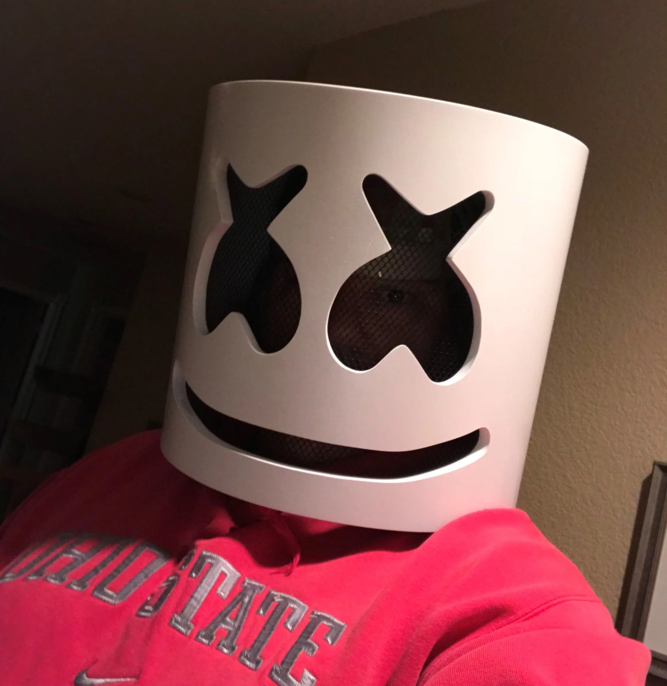 Person wearing Marshmellow Helmet resembling a cartoon skull with holes for eyes and nose, and a big smile, dressed in a red Ohio State hoodie.