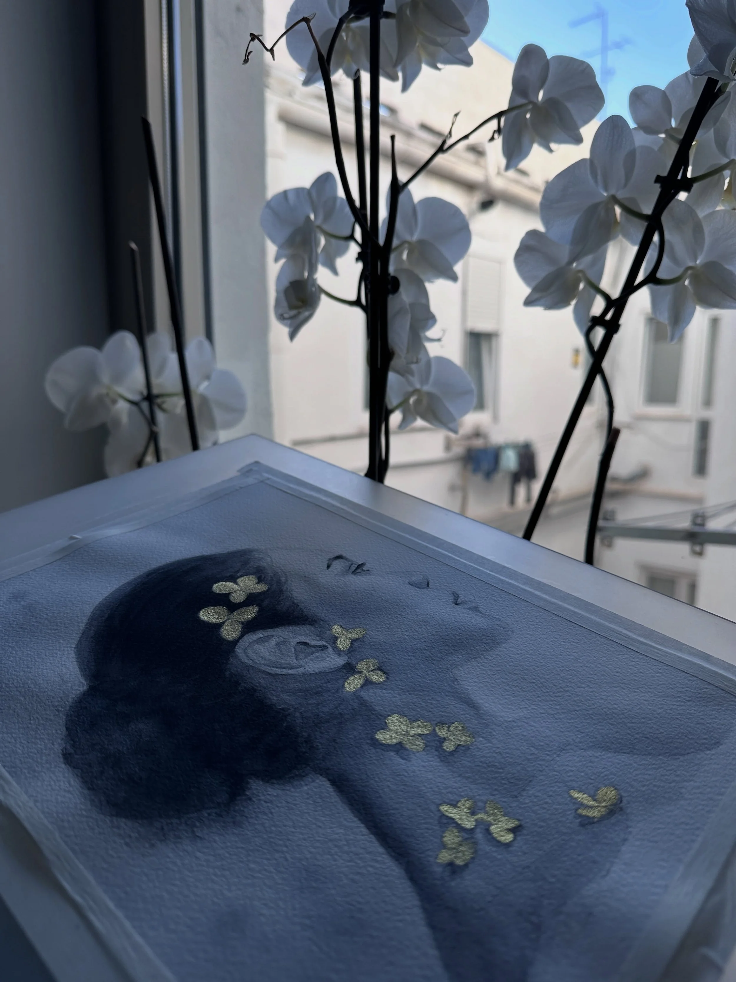 Obra + atm&oacute;sfera
Luz de ma&ntilde;ana, orqu&iacute;deas blancas y una figura en silencio.
 Hay obras que necesitan calma alrededor para terminar de existir.
He disfrutado much&iacute;simo creando esta pieza con carboncillo l&iacute;quido sobre