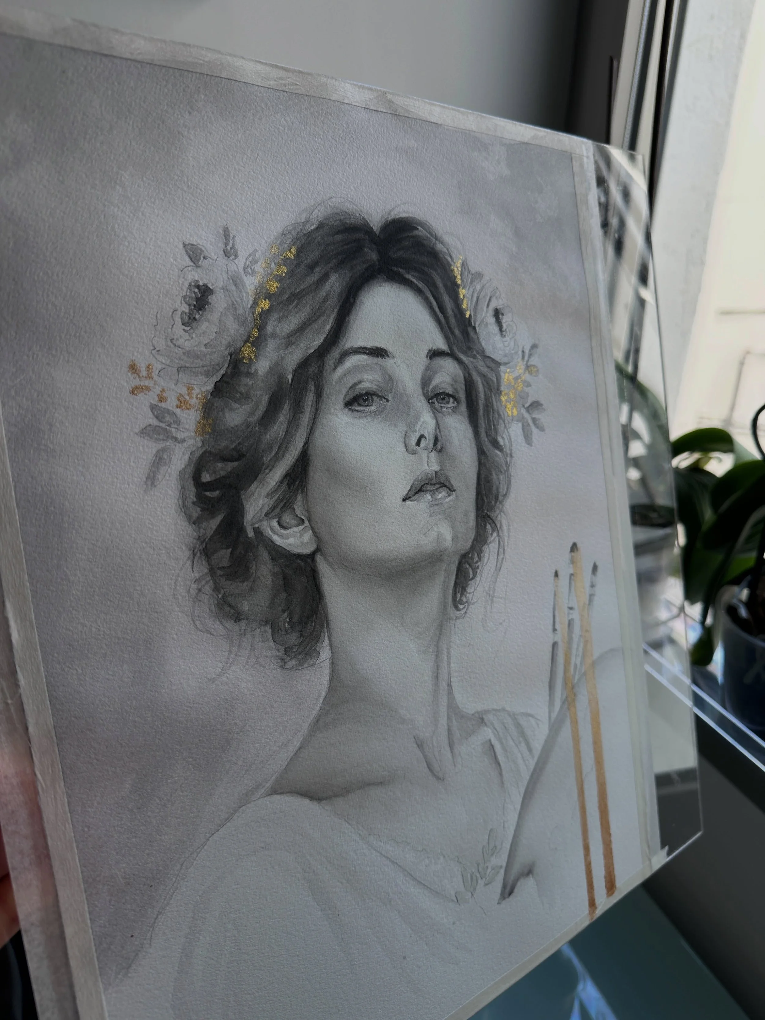 Entre flores y oro
Hay rostros que piden silencio.
En este retrato he querido quedarme con lo esencial: la mirada, el gesto, la delicadeza de unas flores que casi se confunden con el cabello.
Carboncillo l&iacute;quido, agua y peque&ntilde;os toques 