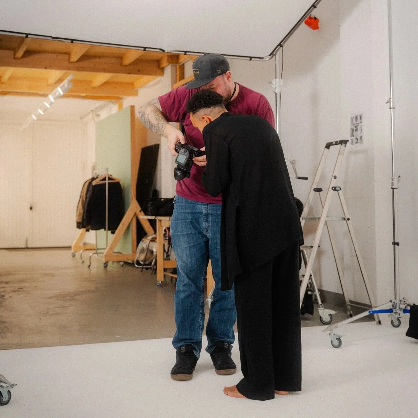 Der Fotograf zeigt dem Modell Ergebnisse auf der Kamera. Sie stehen in einem Studio in Mainz.