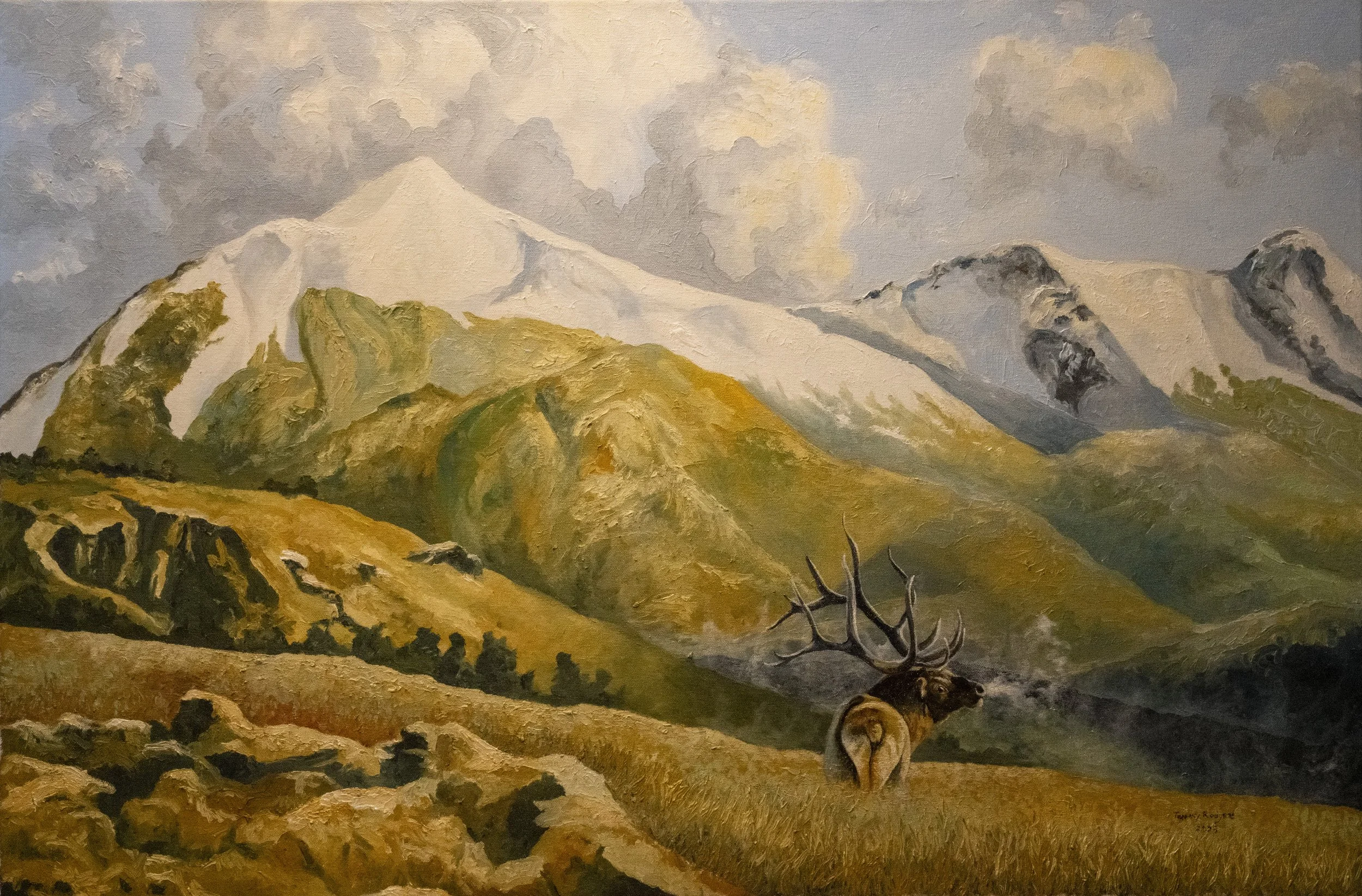 Painting of a mountain landscape with snow-capped peaks, green and yellow rolling hills, a cloudy sky, and a dead tree in the foreground.