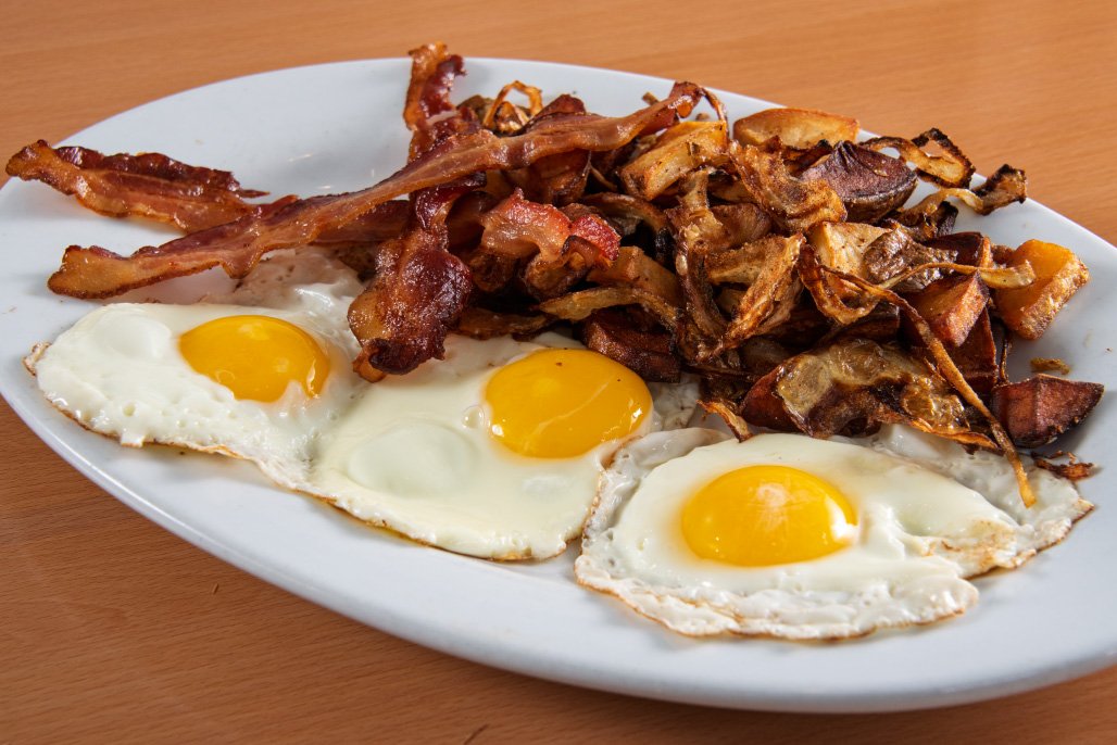 Three Eggs Sunny Up with a pile of bacon