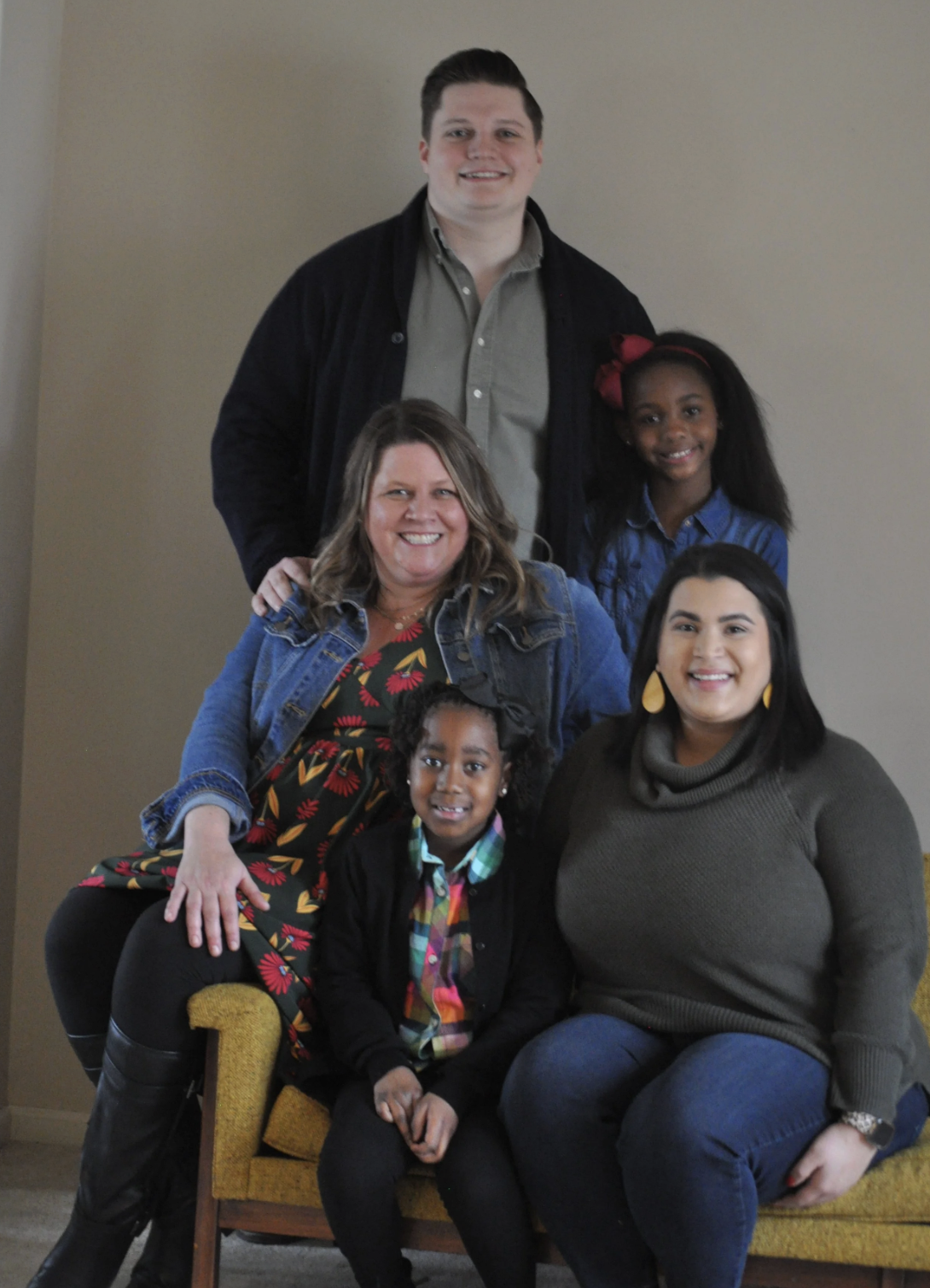 Family of six, including children and adults, posing together indoors, smiling for a photo.