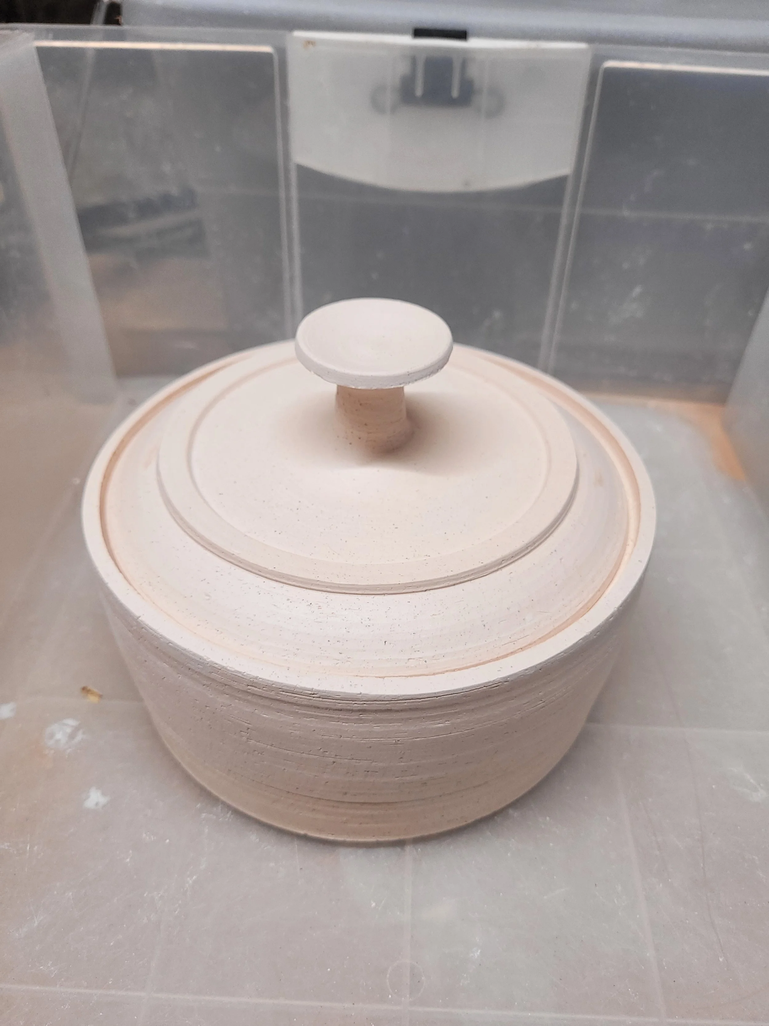A ceramic piece on a wheel in a pottery studio, in the process of being shaped or decorated.