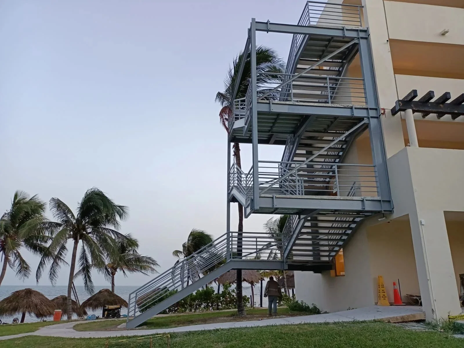 "Escalera metálica estructural de emergencia instalada en hotel frente al mar en Cancún, fabricada por Seaak"